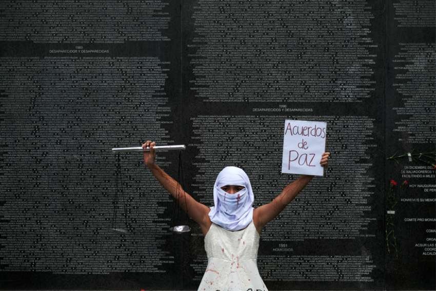 Un activista es fotografiado frente al Monumento a la Memoria y la Verdad en el Parque Cuscatlan en San Salvador, El Salvador, el 16 de enero de 2021, durante una protesta para conmemorar el 29 aniversario de la firma de los acuerdos de paz que puso fin a la guerra civil de El Salvador. Foto del CNS/José Cabezas, Reuters