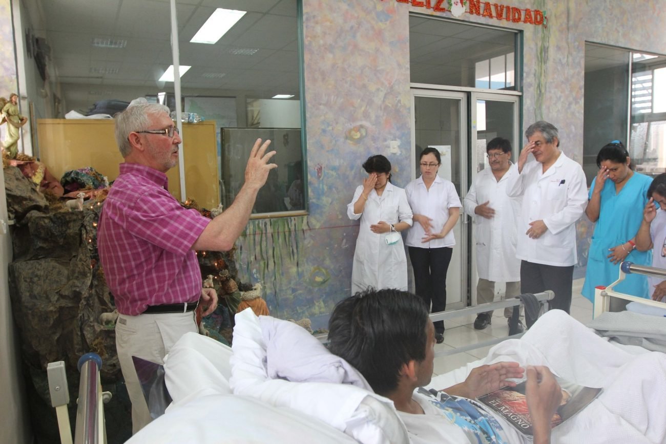 Maryknoll Padre Joe Fedora reza con el personal y pacientes en el pabellón de enfermedades infecciosas Santa Rosa en el Hospital Dos de Mayo de Lima en esta foto de archivo de 2014. Después de que un tribunal de Lima dictaminara que una mujer con una enfermedad terminal podría poner fin a su vida, los obispos peruanos expresaron empatía pero se opusieron a la eutanasia, un tema que se ha vuelto prominente en la campaña presidencial del país. (Foto CNS/Barbara Fraser)