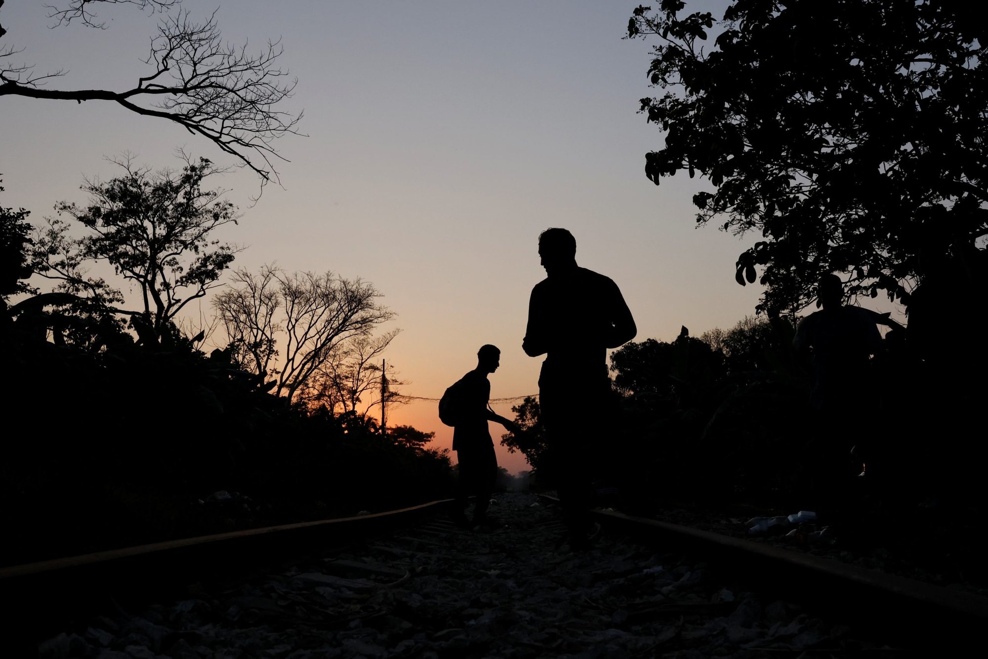Un grupo de migrantes centroamericanos descansan a lo largo de la vía férrea en Macuspana, México, el 25 de marzo de 2021, en su camino a los Estados Unidos. (Foto CNS/Carlos Jasso, Reuters)