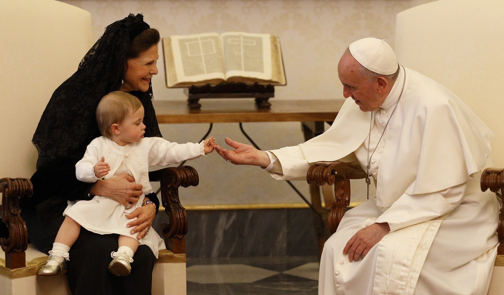 La princesa Leonore, sostenida por la reina Silvia de Suecia, le entrega un llavero papal al papa Francisco durante la audiencia privada de su abuela con el Santo Padre en el Palacio Apostólico del Vaticano en esta foto de archivo del 27 de abril de 2015. El papa ha elegido el tema "Estoy contigo todos los días" para la primera Jornada Mundial de los Abuelos y las Personas Mayores, que se celebrará el 25 de julio de 2021 (Foto de CNS / Paul Haring)