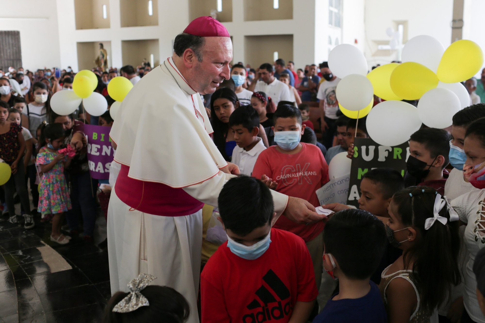 El arzobispo Franco Coppola, nuncio apostólico en México, regala un rosario a un niño durante una visita a Aguililla el 23 de abril de 2021. Los cárteles de la droga en la zona se han enfrentado los unos con los otros y han bloqueado carreteras en la ciudad asediada, dejando a los residentes sin poder viajar libremente y provocando escasez de todo, desde comida hasta combustible. (Foto de CNS/Alan Ortega, Reuters)