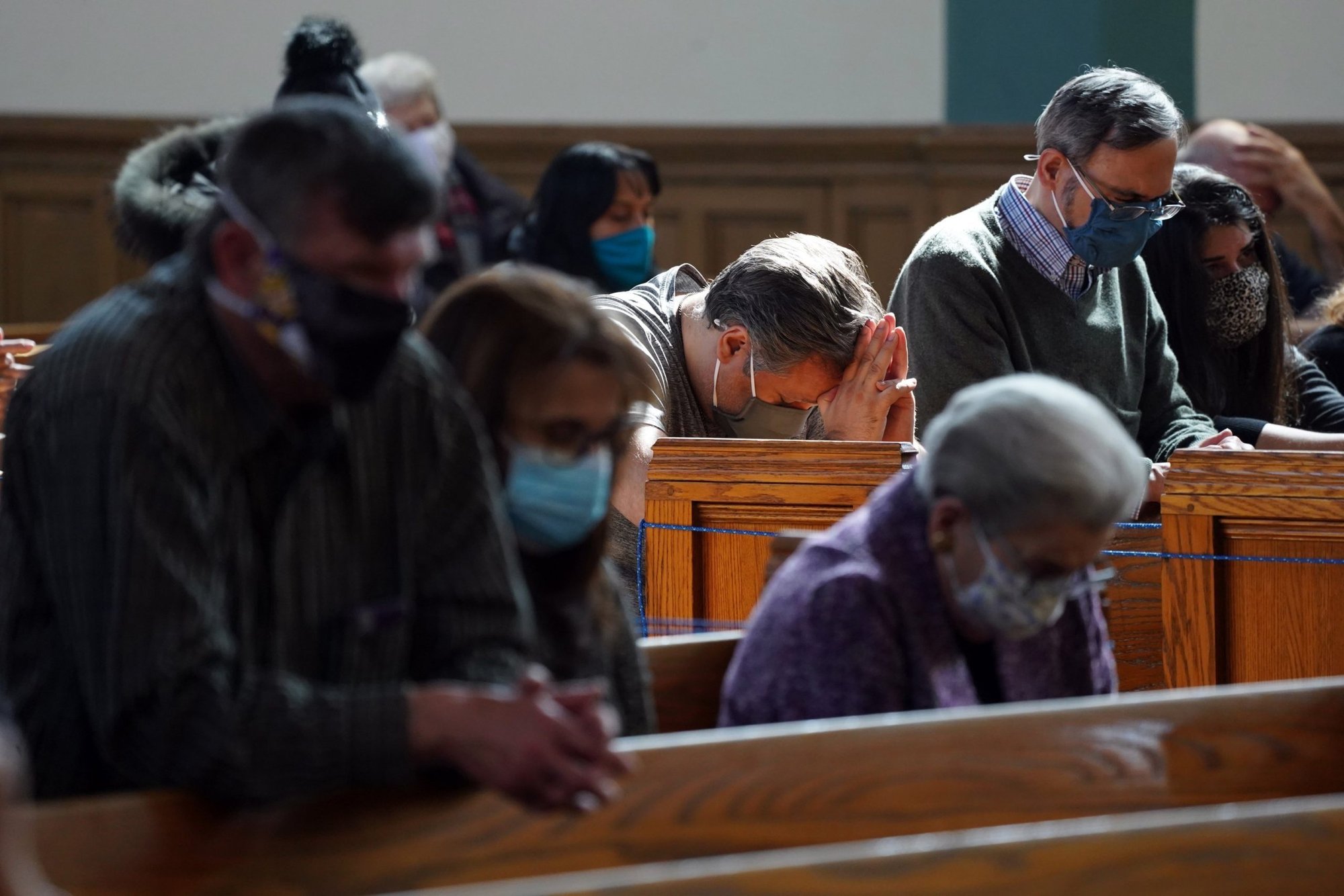 Un grupo de fieles reza durante una misa conmemorativa bilingüe el 13 de marzo de 2021 por los feligreses que han muerto de COVID-19 en la iglesia St. John-Visitation en el barrio del Bronx de Nueva York. Los Centros para el Control y la Prevención de Enfermedades anunciaron el 27 de abril que las personas completamente vacunadas pueden asistir de manera segura a los servicios de adoración en interiores pero deben ponerse mascarillas.(Foto CNS/Gregory A. Shemitz)