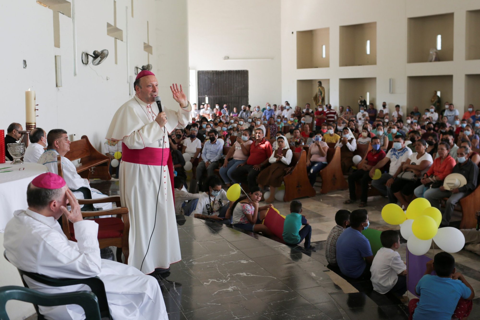 El arzobispo Franco Coppola, nuncio apostólico en México, regala un rosario a un niño durante una visita a Aguililla el 23 de abril de 2021. El nuncio dijo a la agencia de noticias EFE que funcionarios de la iglesia mexicana anteriormente "encubrieron" casos de abuso sexual clerical. (Foto CNS/Alan Ortega, Reuters)