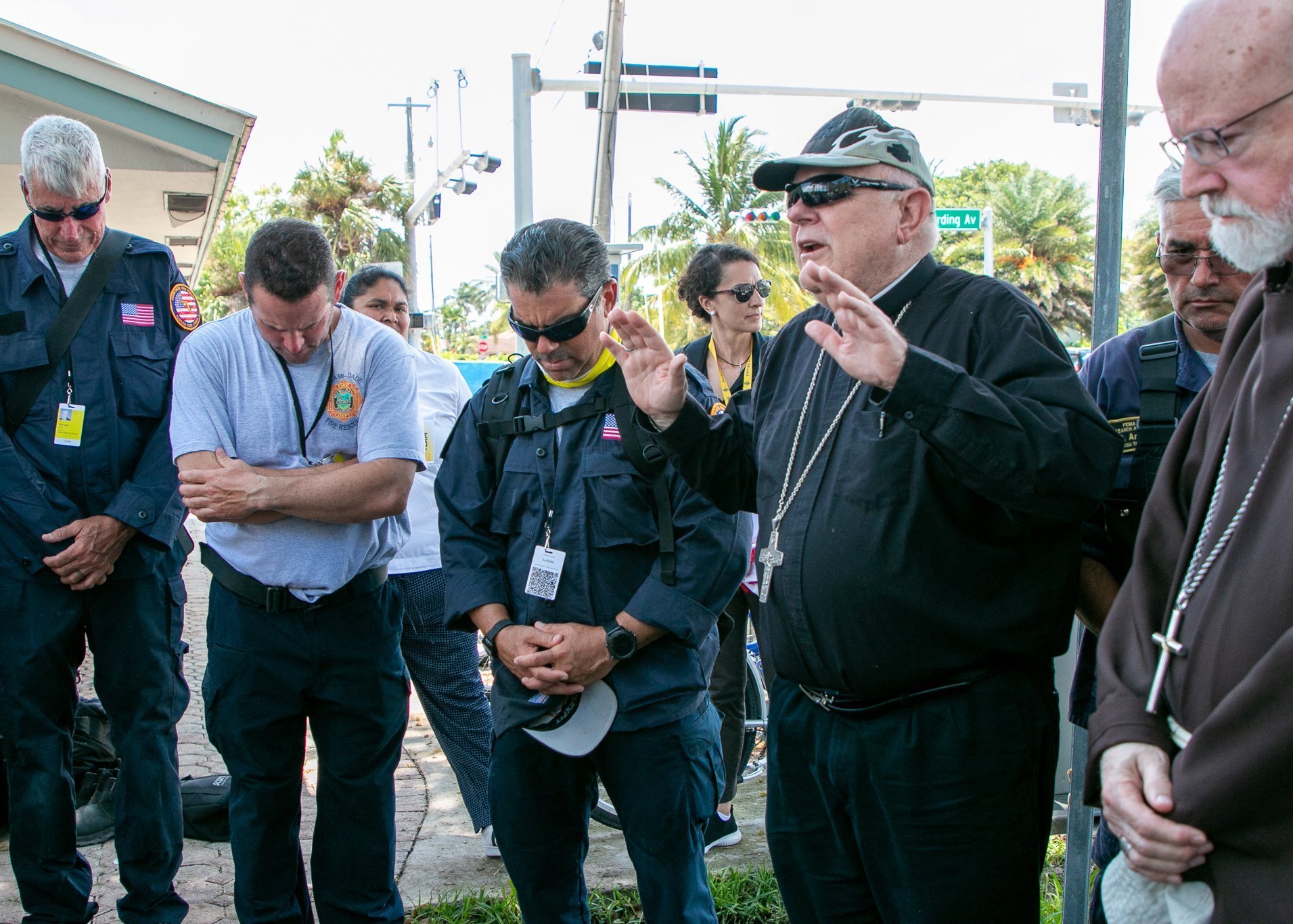 El arzobispo Thomas G. Wenski de Miami bendice al personal de búsqueda y rescate en Surfside, Florida, el 2 de julio de 2021, después de llegar al sitio del colapso de la torre Champlain Towers sur con el cardenal Sean P. O'Malley de Boston. El arzobispo y el cardenal rezaron y bendijeron el sitio mientras también visitaban, rezaban y bendecían a los equipos de búsqueda y rescate que han estado trabajando 24 horas al día, 7 días a la semana desde el colapso. (Foto CNS/Ana Rodriguez-Soto, Florida Catholic)