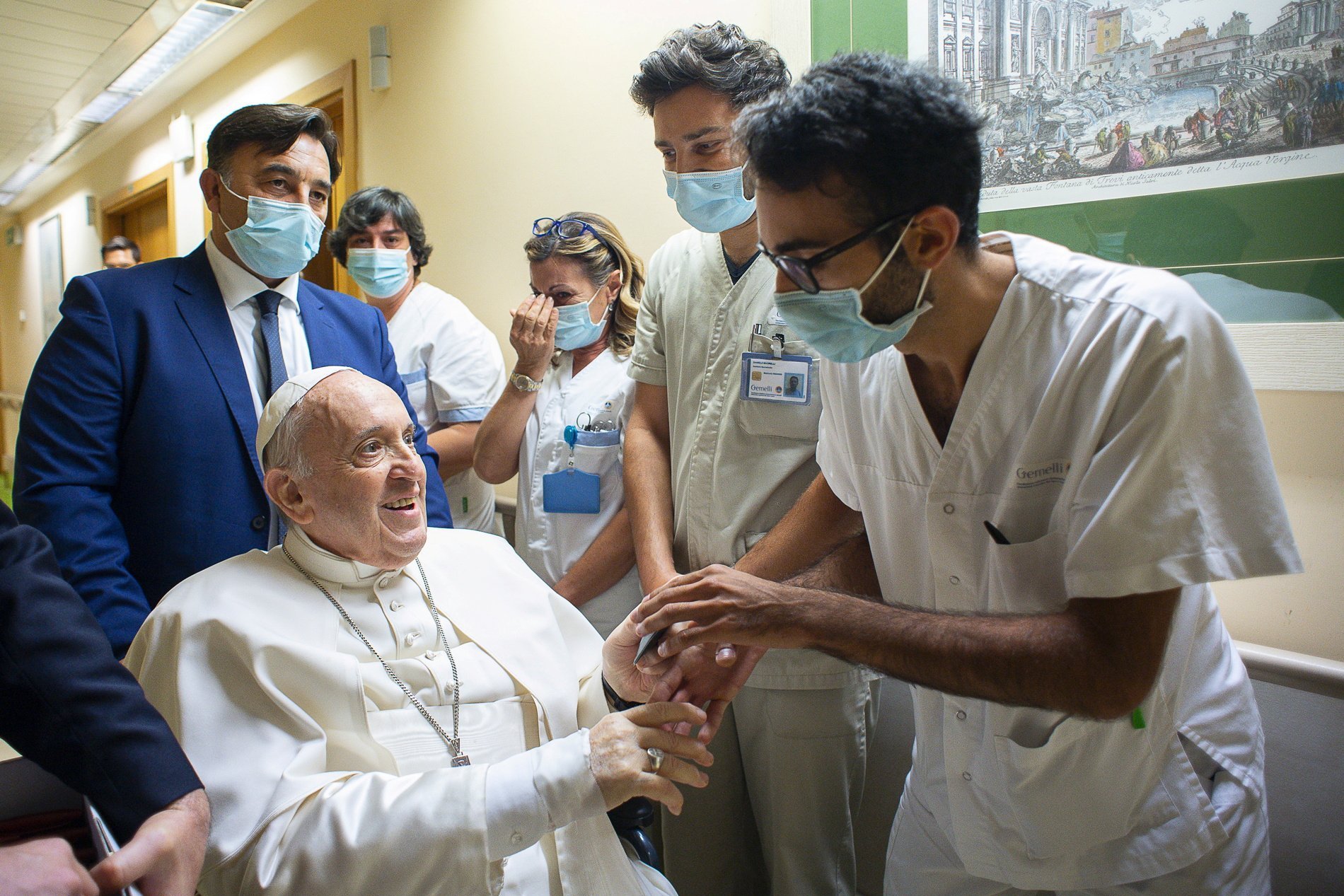 El Papa Francisco entrega un rosario a un miembro del personal médico del hospital Gemelli de Roma el 11 de julio de 2021, mientras se recupera tras una operación de colon programada. El Papa expresó su gratitud por "hacerme sentir como en casa" mientras se recuperaba de la operación, en una carta del 15 de julio al presidente del consejo de administración del hospital. Fue dado de alta el 14 de julio. (Foto CNS/Vatican Media vía Reuters)