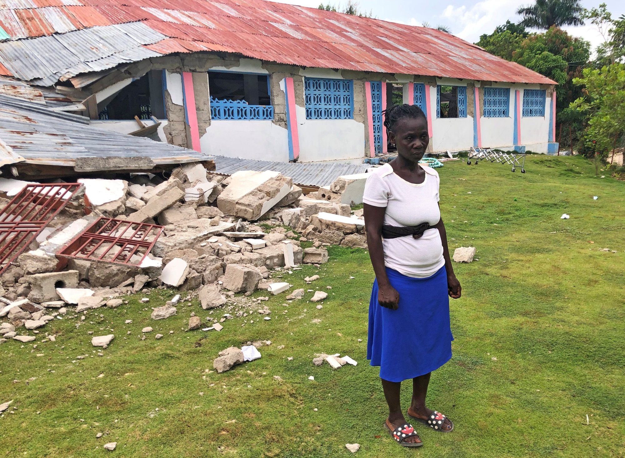 Kettney Francois posa ante los restos de la iglesia de St. Famille du Toirac en Toirac, Haití, el 16 de agosto de 2021. Francois fue pisoteado en una frenética estampida de personas que intentaban escapar tras el terremoto de magnitud 7,2 que sacudió el país durante una misa funeral en la iglesia. (Foto CNS /Laura Gottesdiener, Reuters)