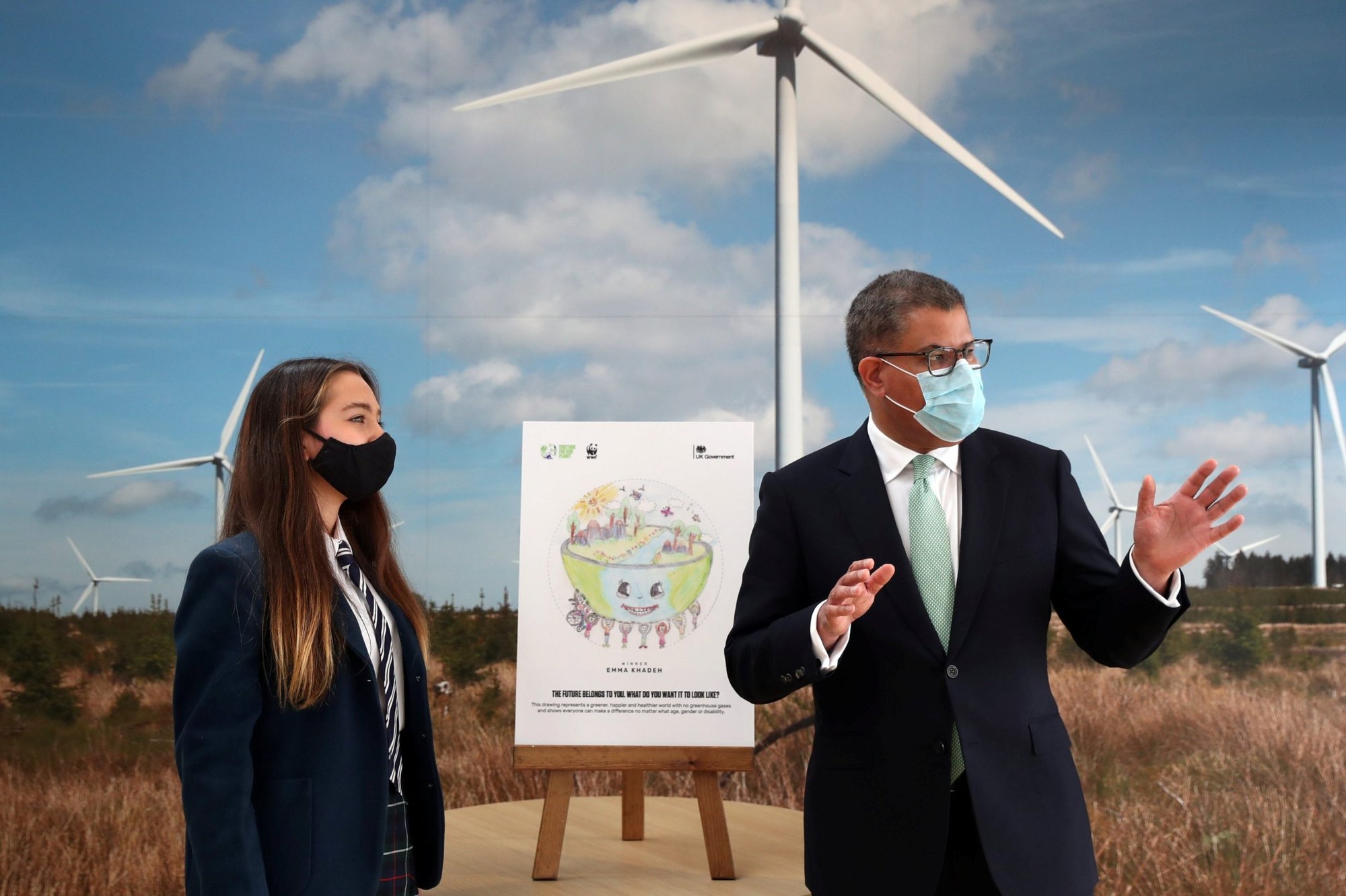 Alok Sharma, presidente de la Conferencia de Cambio Climático para la ONU, hace una presentación junto a Emma Khadeh y su pieza ganadora del concurso de arte, durante un evento en Whitelee Windfarm, marcando seis meses que faltan para la conferencia sobre el cambio climático en las afueras de Glasgow, Escocia, el 14 de mayo de 2021. En una entrevista de radio a fines de agosto, el papa Francisco confirmó que tiene planes de asistir a la conferencia en noviembre de este año. (Foto CNS/Russell Cheyne, grupo de Reuters)