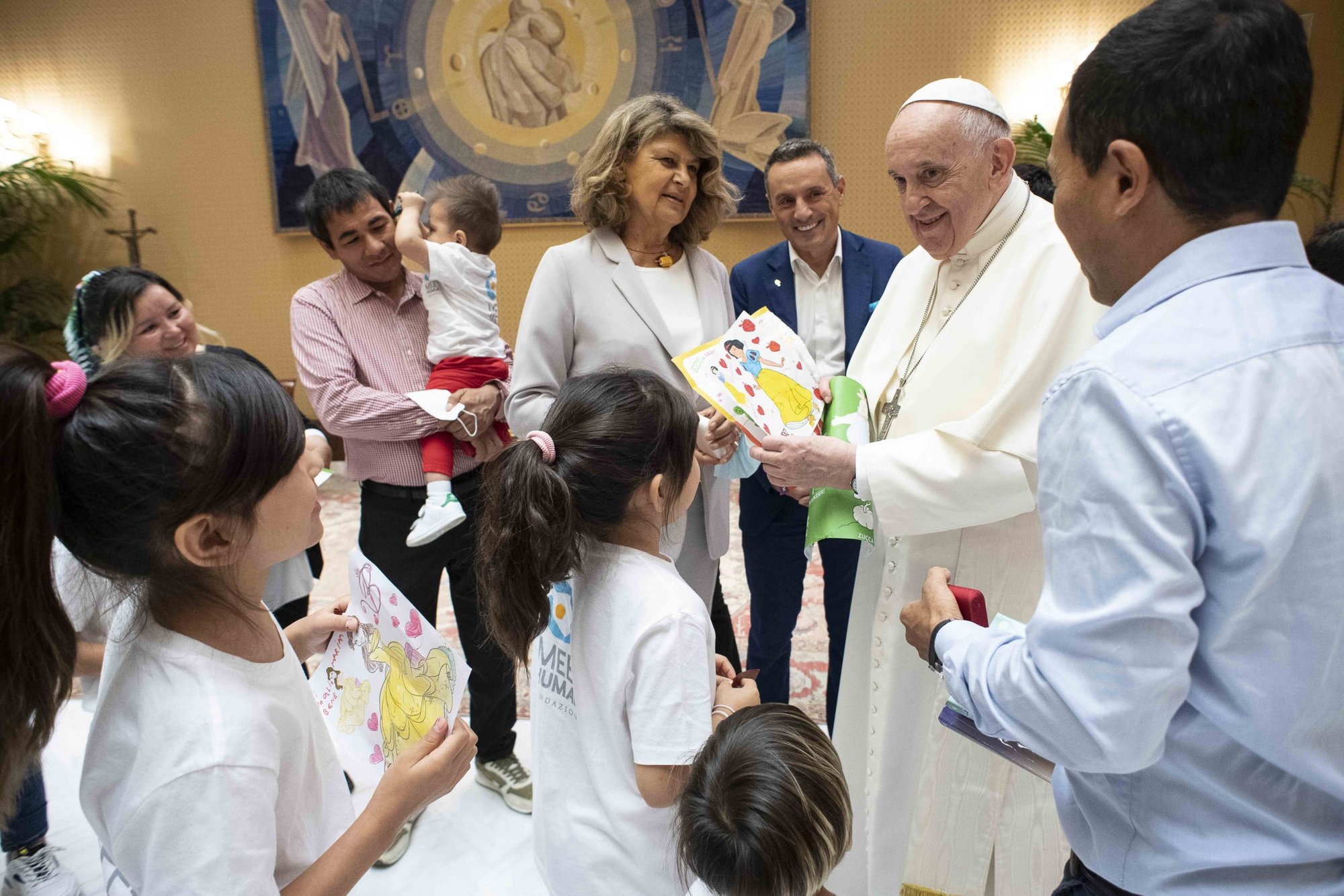 El Papa Francisco acepta obras de arte de niños mientras se reúne con familias de Afganistán antes de su audiencia general en el aula Pablo VI del Vaticano el 22 de septiembre de 2021. El Papa se reunió con tres familias cristianas de Afganistán, un total de 14 personas, incluidos siete niños, que huyeron de Afganistán en las últimas semanas. (Foto CNS/Vatican Media)