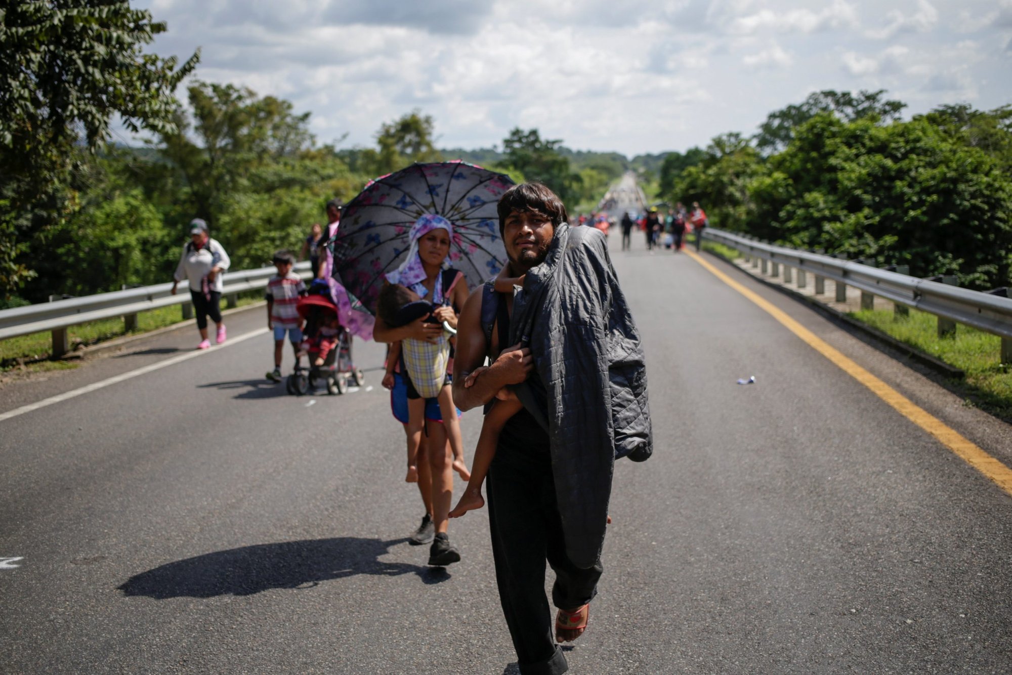 El hondureño Julio César González, de 30 años, y su esposa, Edith Cantillano, de 22, cargan a sus hijos enfermos mientras caminan con una caravana que se dirige a la Ciudad de México, en Villa Comaltitlán, México, el 27 de octubre de 2021. En un mensaje a la Organización Internacional para las Migraciones en noviembre, el papa Francisco pidió a los países que hagan más para abrir vías seguras y legales para la migración. (Foto CNS/Daniel Becerril, Reuters)