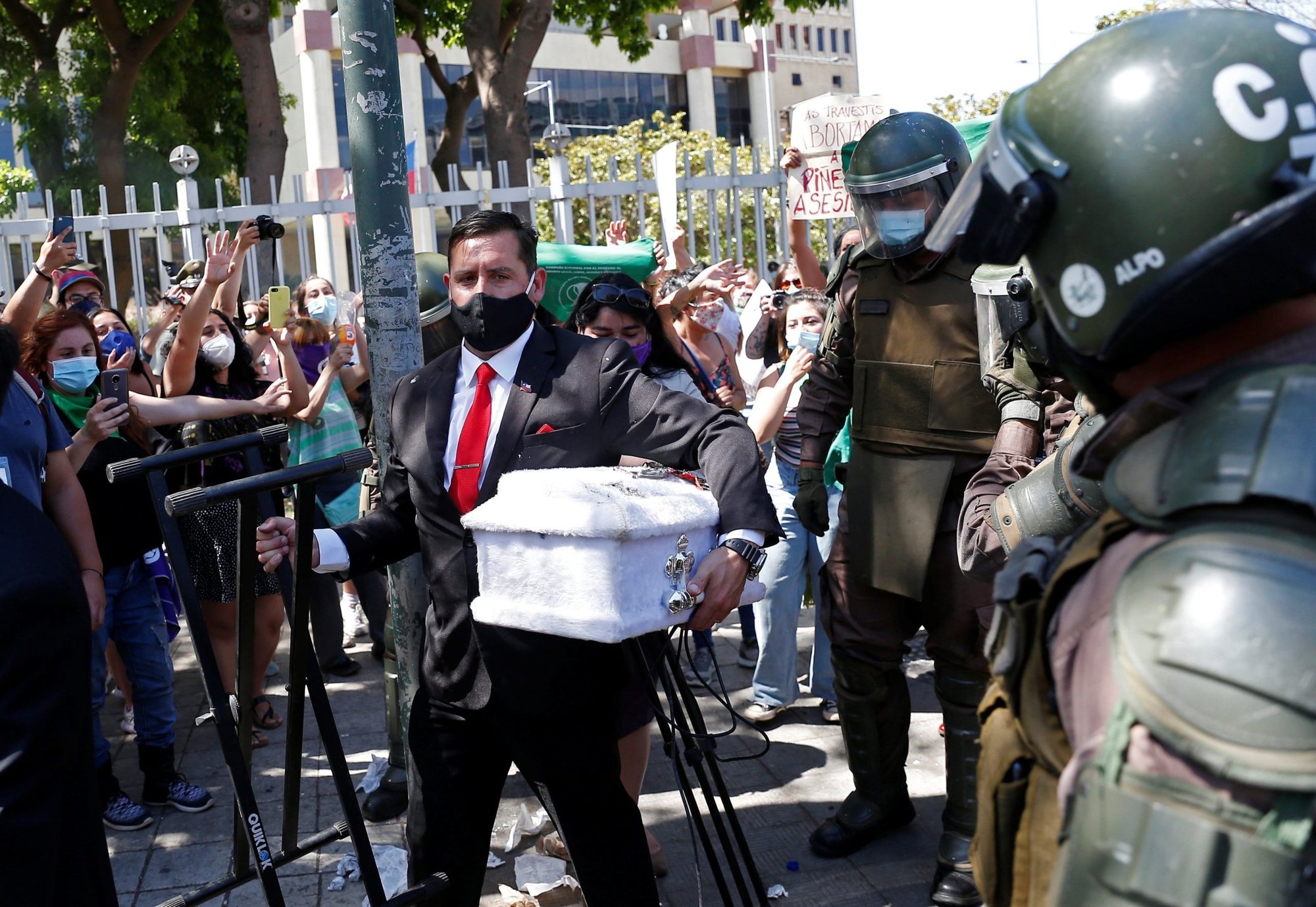 Un predicador con un ataúd vacío del tamaño de un niño es escoltado por agentes de policía cerca de activistas pro-vida y personas a favor de la despenalización del aborto en el exterior del congreso en Valparaíso, Chile, el 13 de enero de 2021. Legisladores en la cámara baja del Congreso de Chile el 30 de noviembre derrotaron un proyecto de ley que habría eliminado las sanciones penales por el aborto durante las primeras 14 semanas de embarazo. (Foto CNS/Rodrigo Garrido, Reuters)