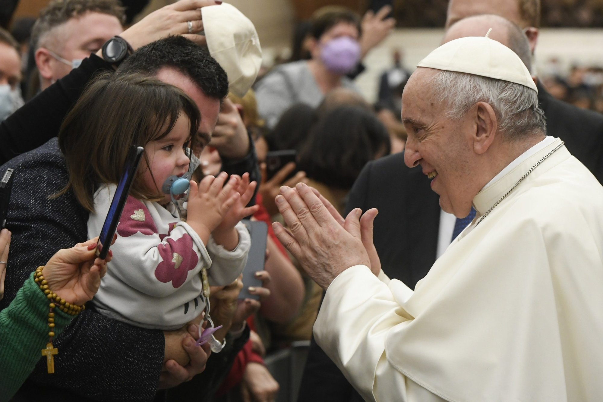 El papa Francisco saluda a una niña después de su audiencia general semanal el 29 de diciembre de 2021 en el salón Pablo VI del Vaticano. (Foto CNS/Vatican Media)