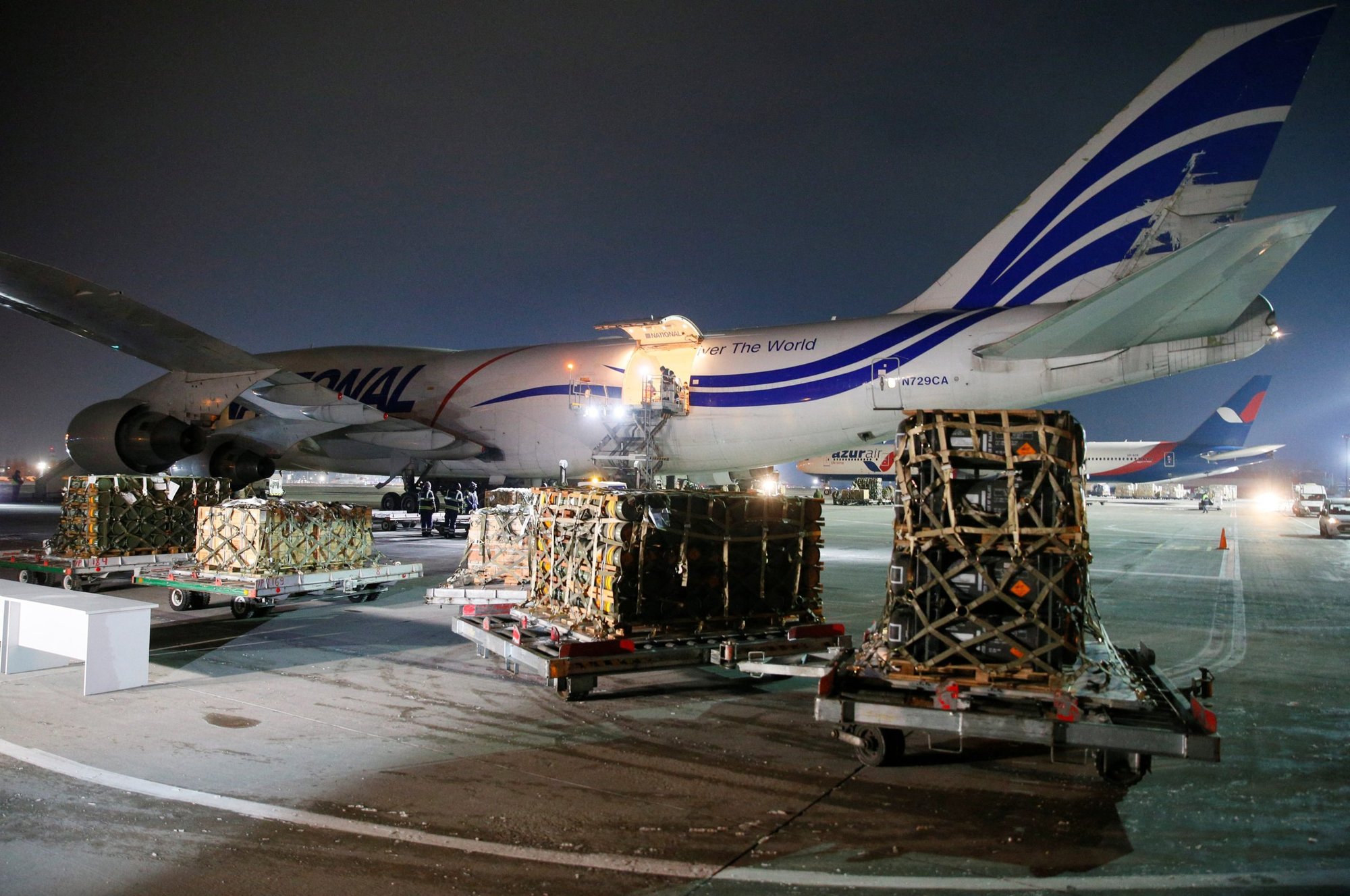 Trabajadores descargan un envío de ayuda militar entregado como parte de la asistencia de seguridad de Estados Unidos de América a Ucrania, en el Aeropuerto Internacional de Boryspil en las afueras de Kiev, Ucrania, el 25 de enero de 2022. (CNS photo/Gleb Garanich, Reuters)