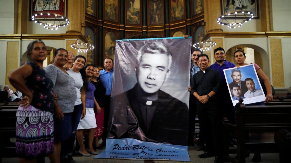 La gente posa con imágenes del padre jesuita Rutilio Grande después de una misa en su honor en una iglesia de San Salvador, El Salvador, el 22 de febrero de 2020. El Vaticano anunció el 22 de febrero que el Papa Francisco reconoció el martirio del Padre Grande y de dos compañeros suyos, que fueron asesinados cuando iban de camino a una novena, en 1977. (Foto CNS/José Cabezas, Reuters)
