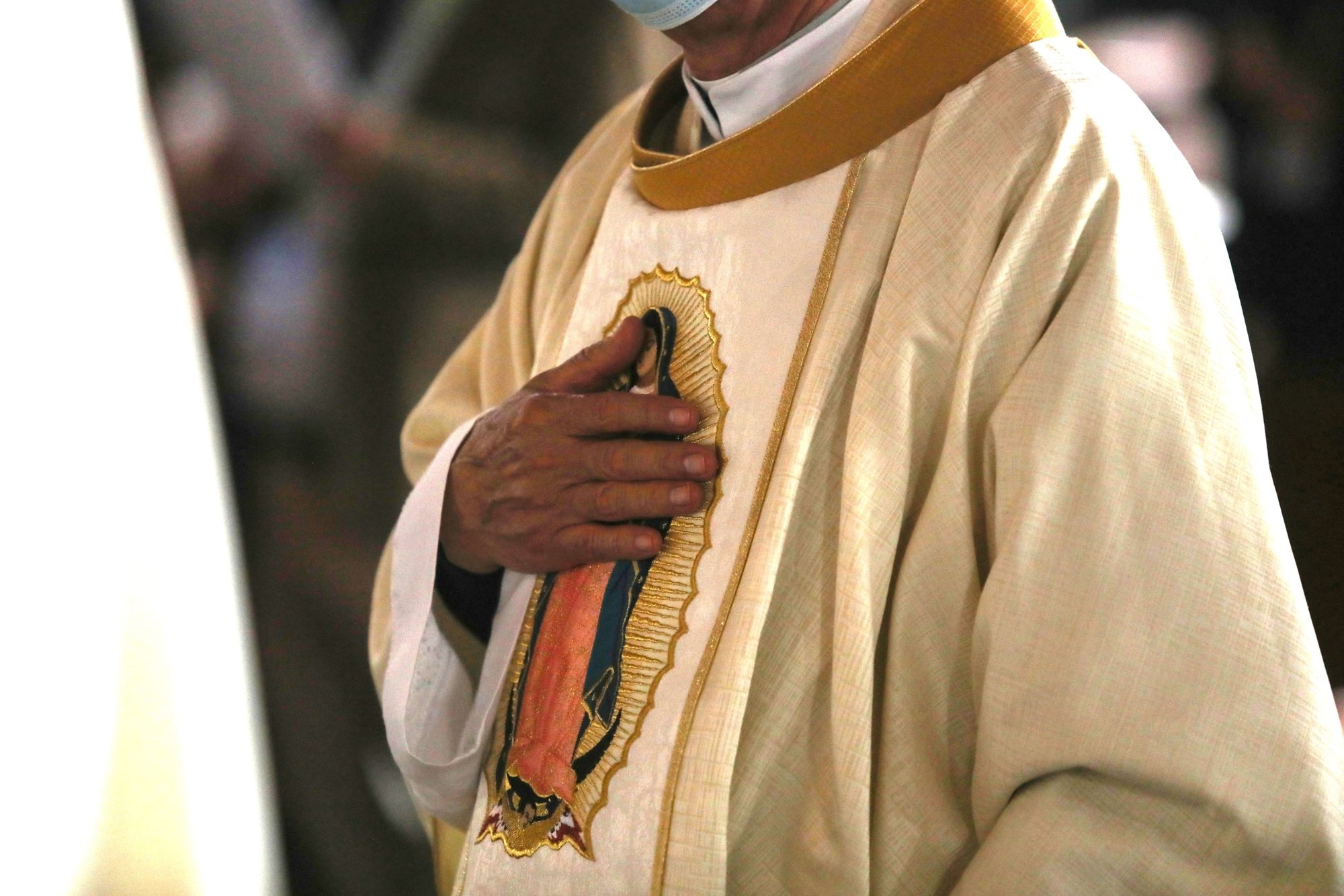 Un clérigo toca una imagen de Nuestra Señora de Guadalupe en sus vestiduras durante una misan en Basílica de Nuestra Señora de Guadalupe en la Ciudad de México el 21 de noviembre de 2021. (Foto CNS /Emilio Espejel)