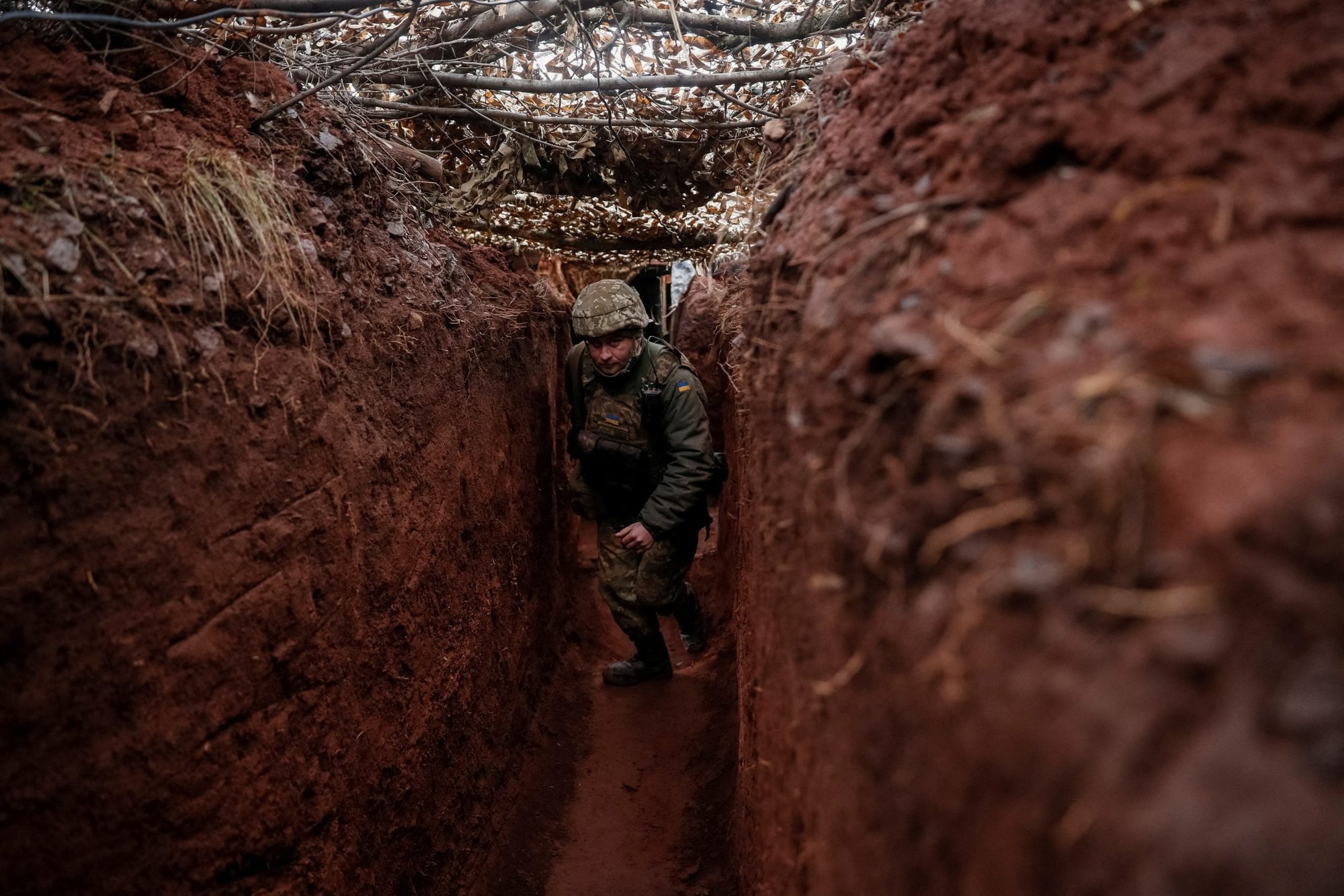 Un soldado ucraniano camina a lo largo de una trinchera en una posición en la línea del frente cerca de la ciudad de Novoluhanske en la región de Donetsk de Ucrania, 22 de febrero de 2022. Dos días después, el presidente ruso Vladimir Putin lanzó un amplio ataque contra ciudades de toda Ucrania. (Foto CNS/Gleb Garanich, Reuters)