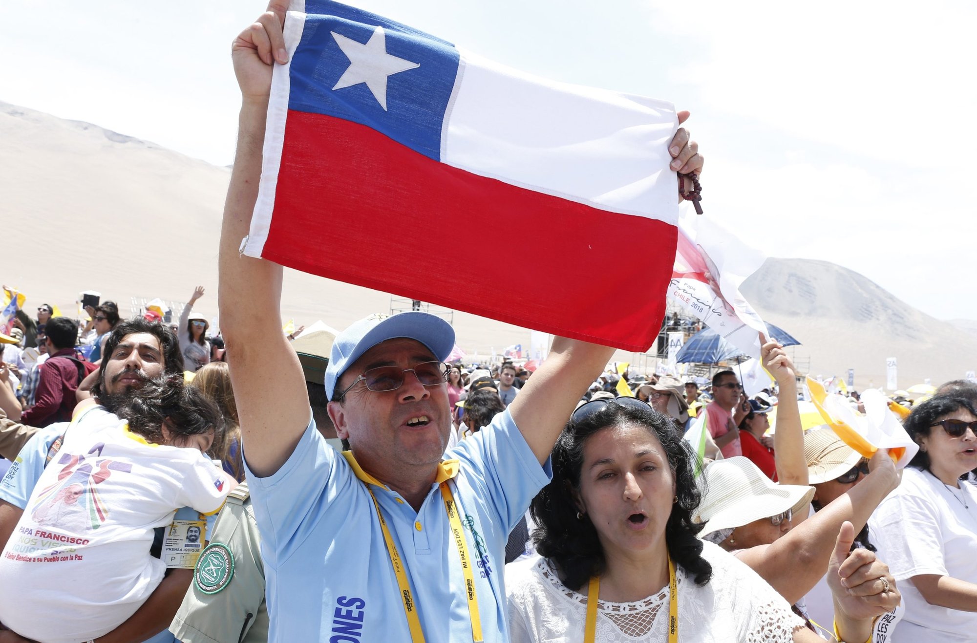Un hombre sostiene la bandera de Chile mientras la gente celebra después de asistir a la celebración de la misa del Papa Francisco en la playa de Lobito, Chile, en esta foto de archivo del 18 de enero de 2018. (Foto CNS /Paul Haring)