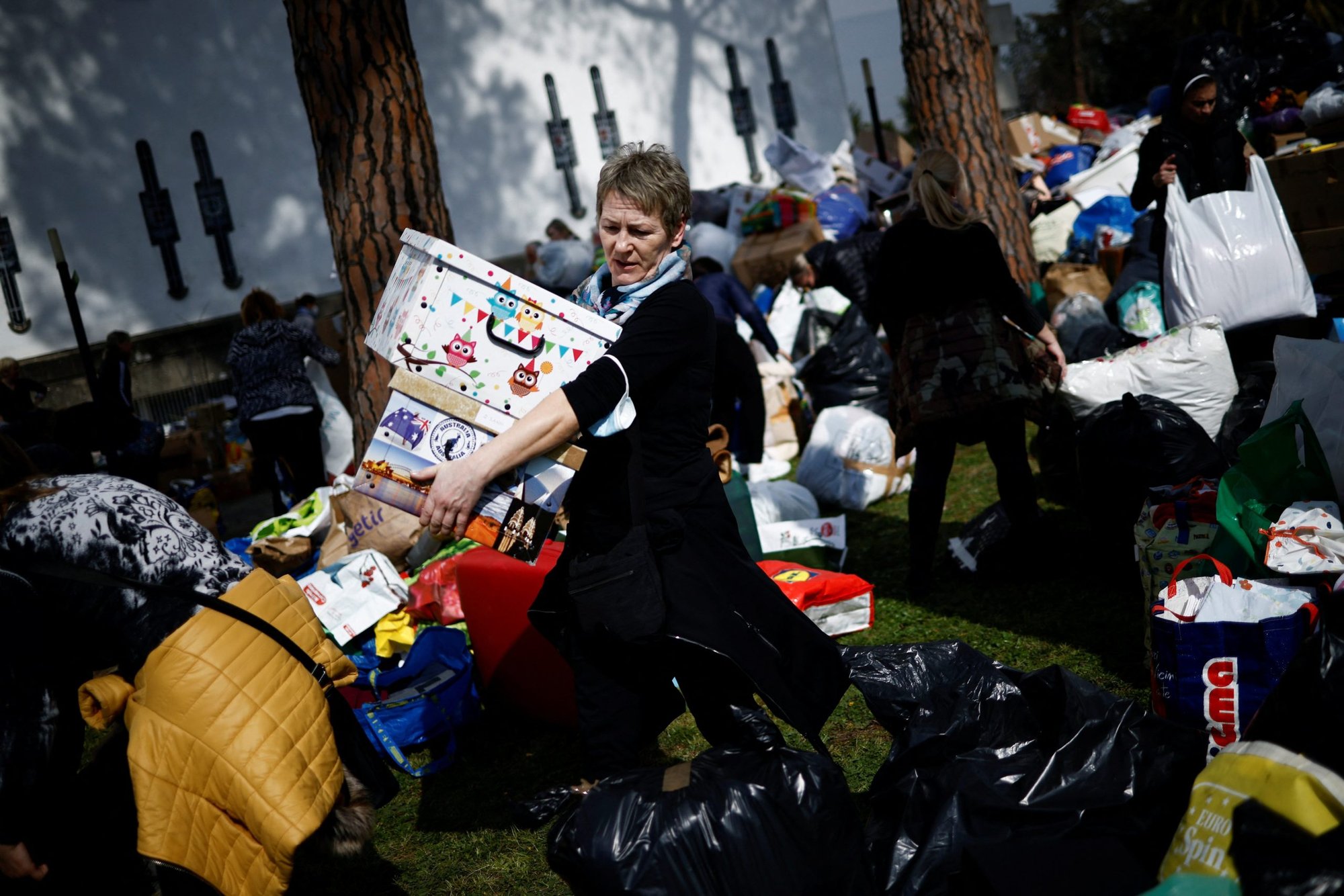 Una mujer lleva productos humanitarios para ser cargados en camiones como transporte de primera ayuda a Ucrania, tras la invasión rusa de Ucrania, en la Basílica de Santa Sofía, un centro religioso y cultural para expatriados ucranianos en Roma, el 3 de marzo de 2022. (Foto Guglielmo Mangiapane/Reuters vía CNS).
