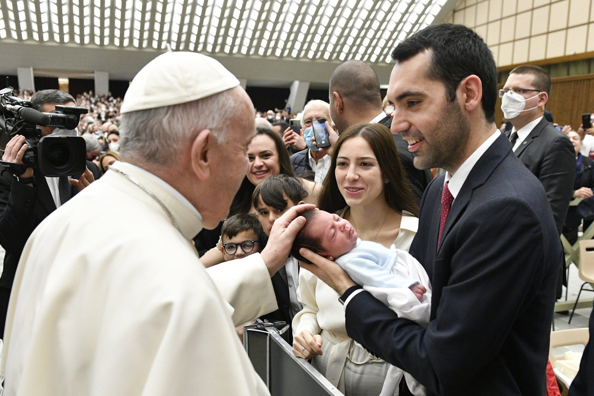 El papa Francisco saluda a un bebé durante su audiencia general en el salón Pablo VI del Vaticano el 16 de marzo de 2022. (Foto CNS/Vatican Media)