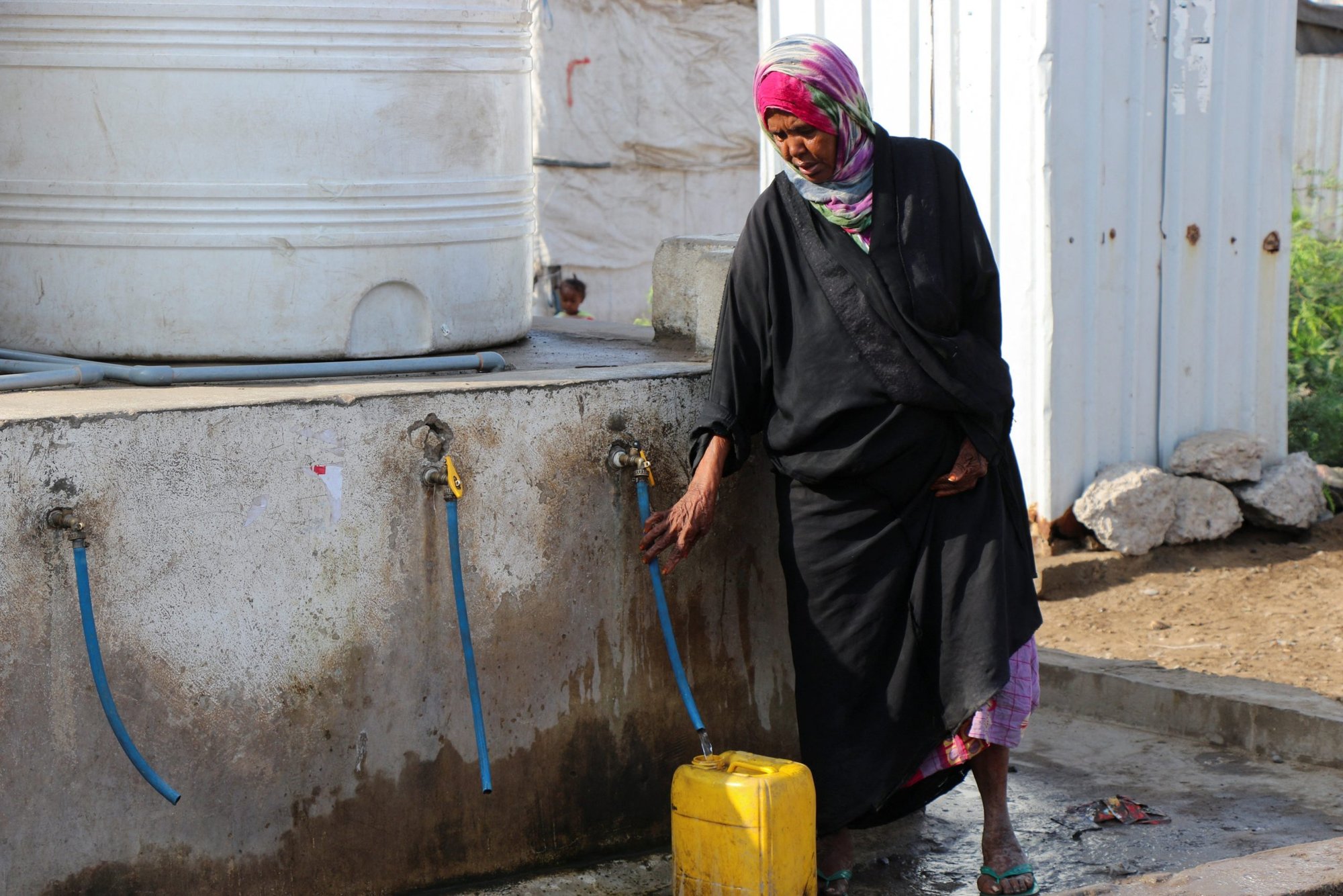 Una mujer llena un contenedor con agua en un campamento improvisado para desplazados internos en Adén, Yemen, el 15 de marzo de 2022. El papa Francisco dijo que las verdaderas batallas que la gente debería pelear son contra el hambre, la sed, las enfermedades, la pobreza y la esclavitud. (Foto CNS/Fawaz Salman, Reuters)