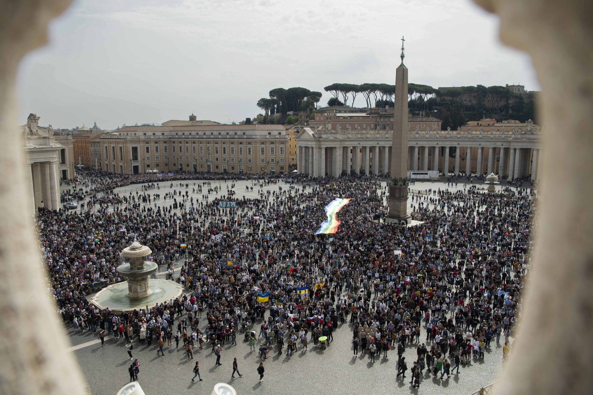 Una bandera de paz aparece en la Plaza de San Pedro mientras el papa Francisco dirige el Ángelus desde la ventana de su estudio con vista a la plaza en el Vaticano el 27 de marzo de 2022. El papa pidió por el fin de la guerra en Ucrania, diciendo que era "bárbara y un acto sacrílego." (Foto CNS/Vatican Media)