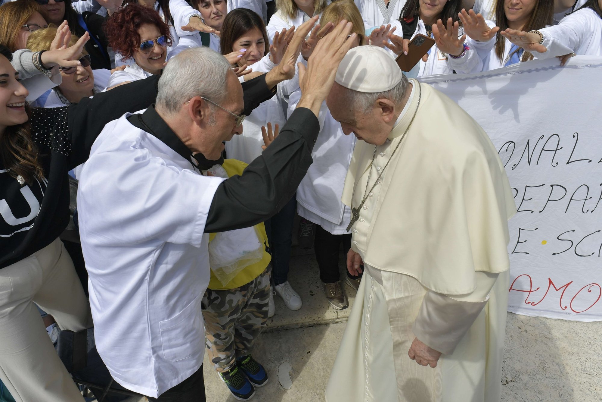 Un sacerdote y otras personas oran por el papa Francisco durante su audiencia general en la Plaza de San Pedro en el Vaticano el 20 de abril de 2022. (Foto CNS/Vatican Media)