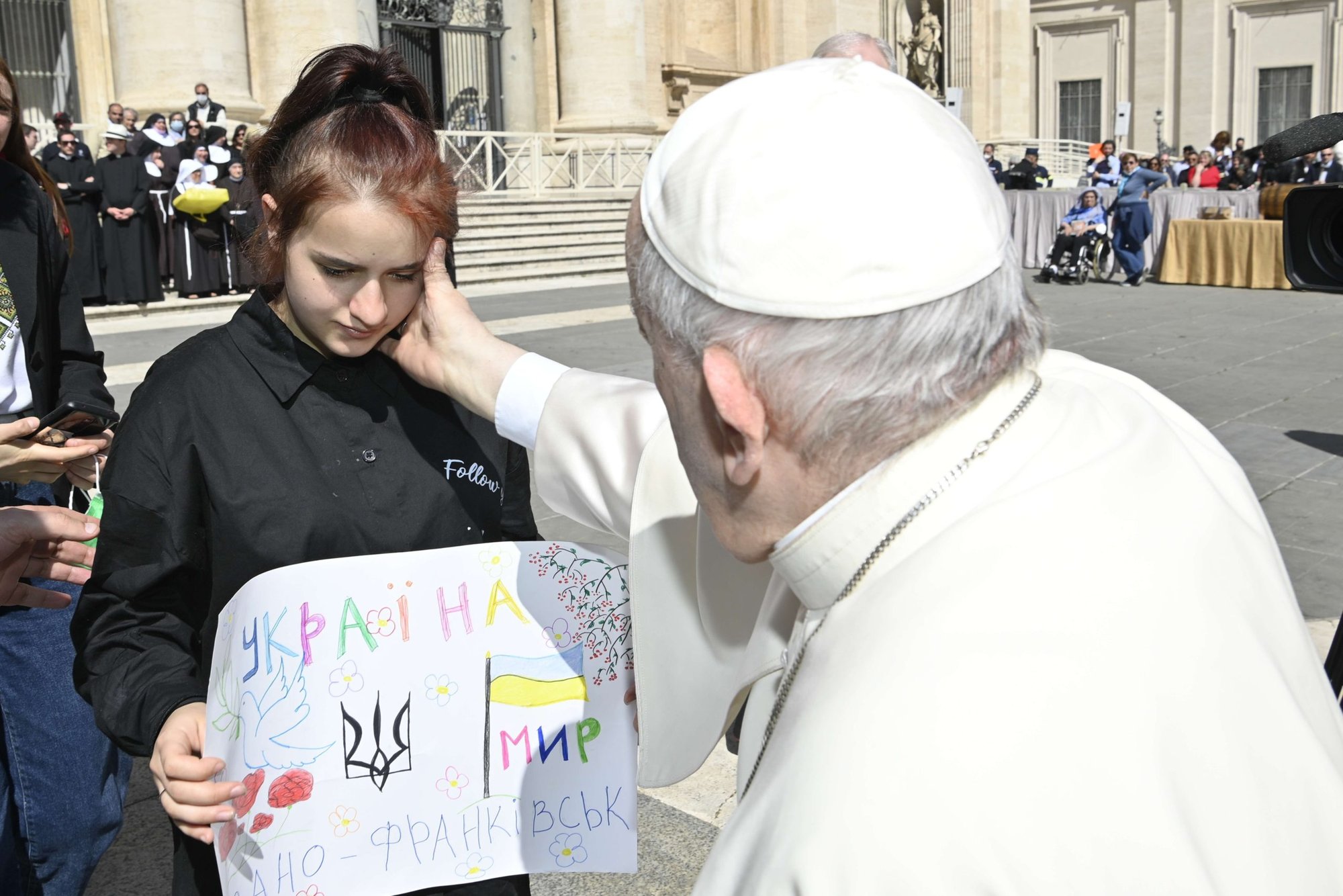 El papa Francisco saluda a una niña mientras se reúne con un grupo de ucranianos después de su audiencia general semanal en la Plaza de San Pedro en el Vaticano el 27 de abril de 2022. Ella era una de 11 huérfanos que escaparon de Ucrania y encontraron ayuda a principios de marzo de una organización católica italiana. (Foto CNS/Vatican Media)