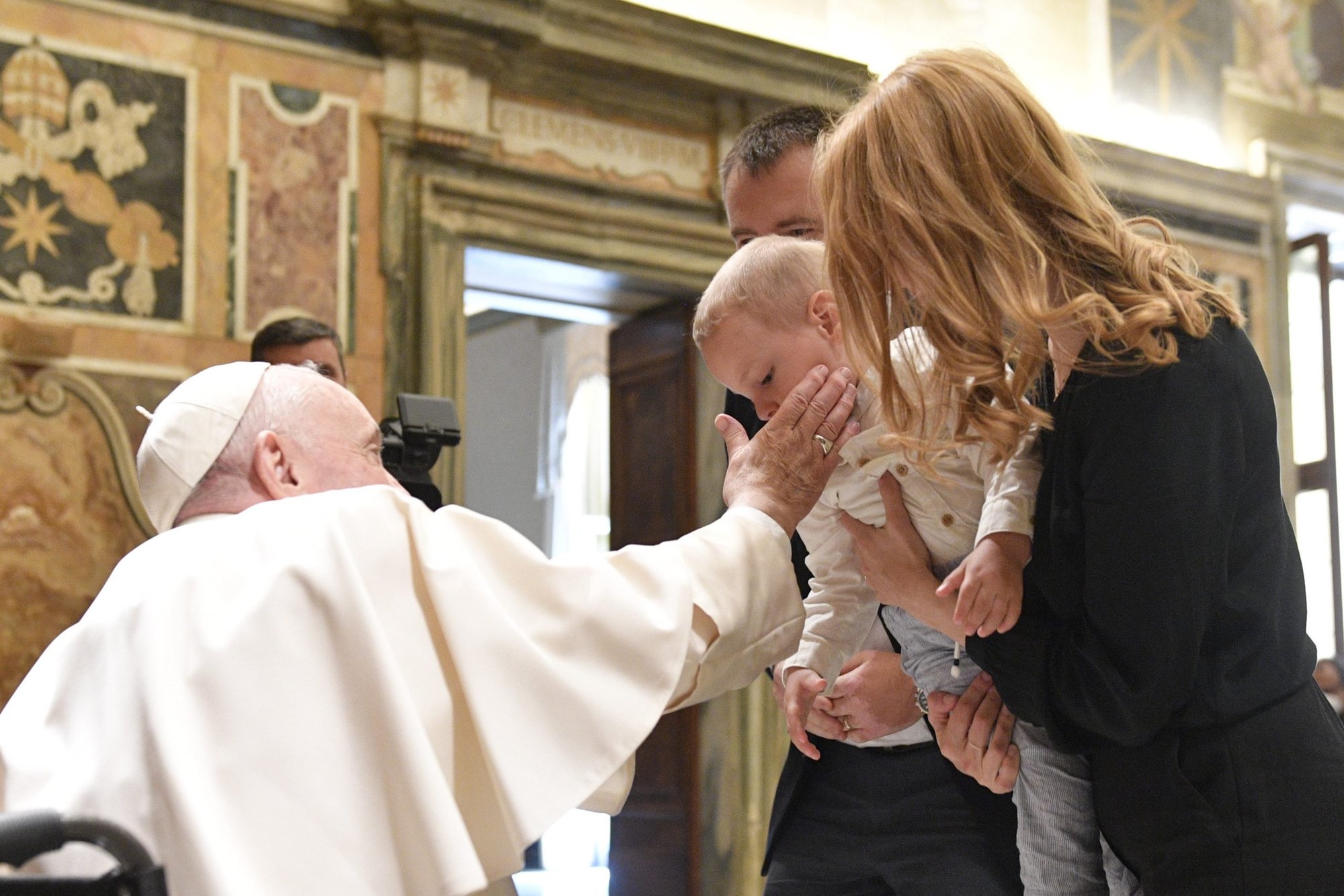 El Papa Francisco acaricia la mejilla de un niño en el Vaticano el 13 de mayo de 2022, mientras saluda a los participantes de una conferencia en Roma en la que se discute sobre la familia y la teología moral. (Foto CNS /Vatican Media)