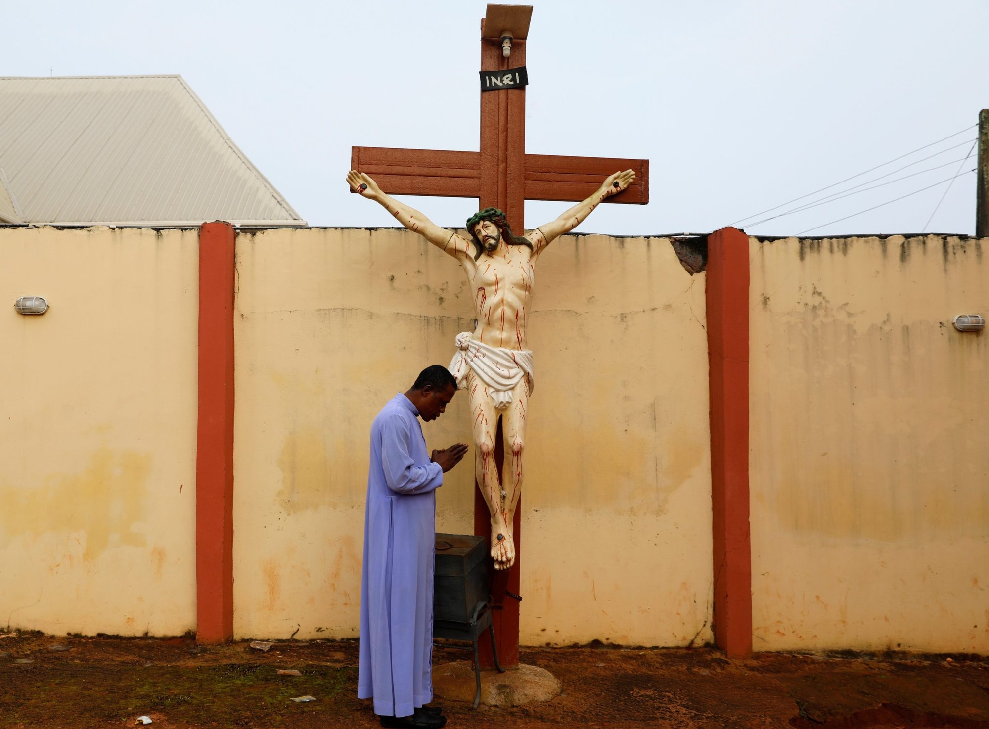 El padre Paul Obayi reza frente al crucifijo en la Catedral de Santa María en Enugu, Nigeria, el 30 de septiembre de 2021. Las iglesias católicas de Sokoto, Nigeria, suspendieron las misas el 15 de mayo de 2022, después de que el gobierno impusiera un toque de queda para sofocar las protestas tras las detenciones por la muerte de un estudiante universitario a manos de la mafia. (Foto CNS /Temilade Adelaja, Reuters)
