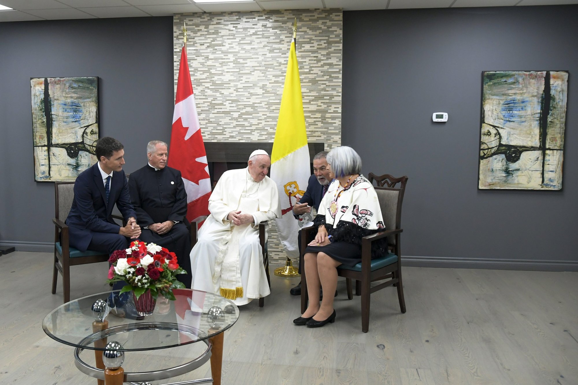 El papa Francisco besa la mano de la sobreviviente de la escuela residencial Alma Desjarlais de la Primera Nación de Frog Lake durante una ceremonia de bienvenida en el Aeropuerto Internacional de Edmonton el 24 de julio de 2022. El papa estaba comenzando una visita de seis días a Canadá. (Foto CNS/Vatican Media)