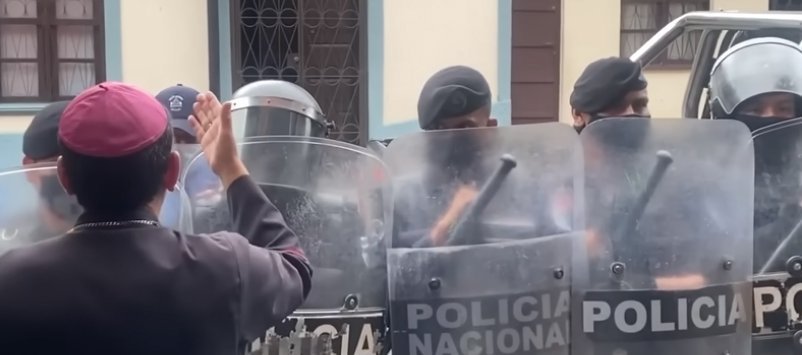 Monseñor Rolando José Álvarez, obispo de Matagalpa, Nicaragua, aparece en esta captura de pantalla de un video en Matagalpa mientras la policía antidisturbios bloquea la puerta. El obispo dijo que la policía le impedía a él, a seis sacerdotes y a seis laicos salir de las oficinas diocesanas locales. (Foto Captura de pantalla del CNS/YouTube)