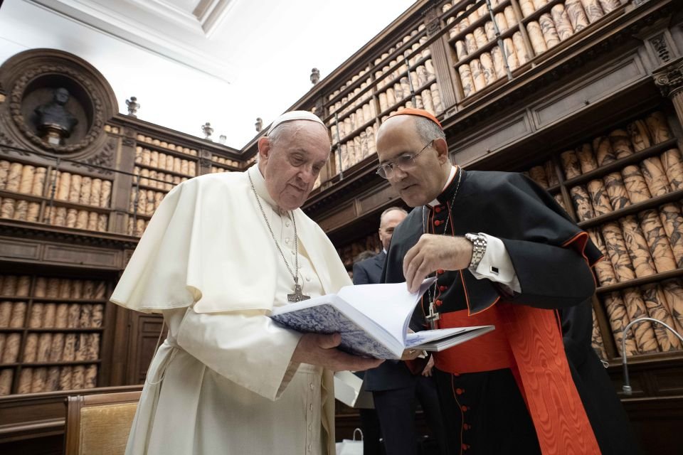 El Papa Francisco habla con el cardenal José Tolentino Calaca de Mendonca, archivero y bibliotecario del Vaticano, durante una ceremonia en la Biblioteca Vaticana el 5 de noviembre de 2021. La Biblioteca Vaticana, una de las bibliotecas más antiguas del mundo, ha lanzado una nueva revista académica para ayudar a promover la investigación de alta calidad, el diálogo entre culturas y el intercambio de conocimientos, dijo el cardenal Mendonca. (Foto CNS /Vatican Media)