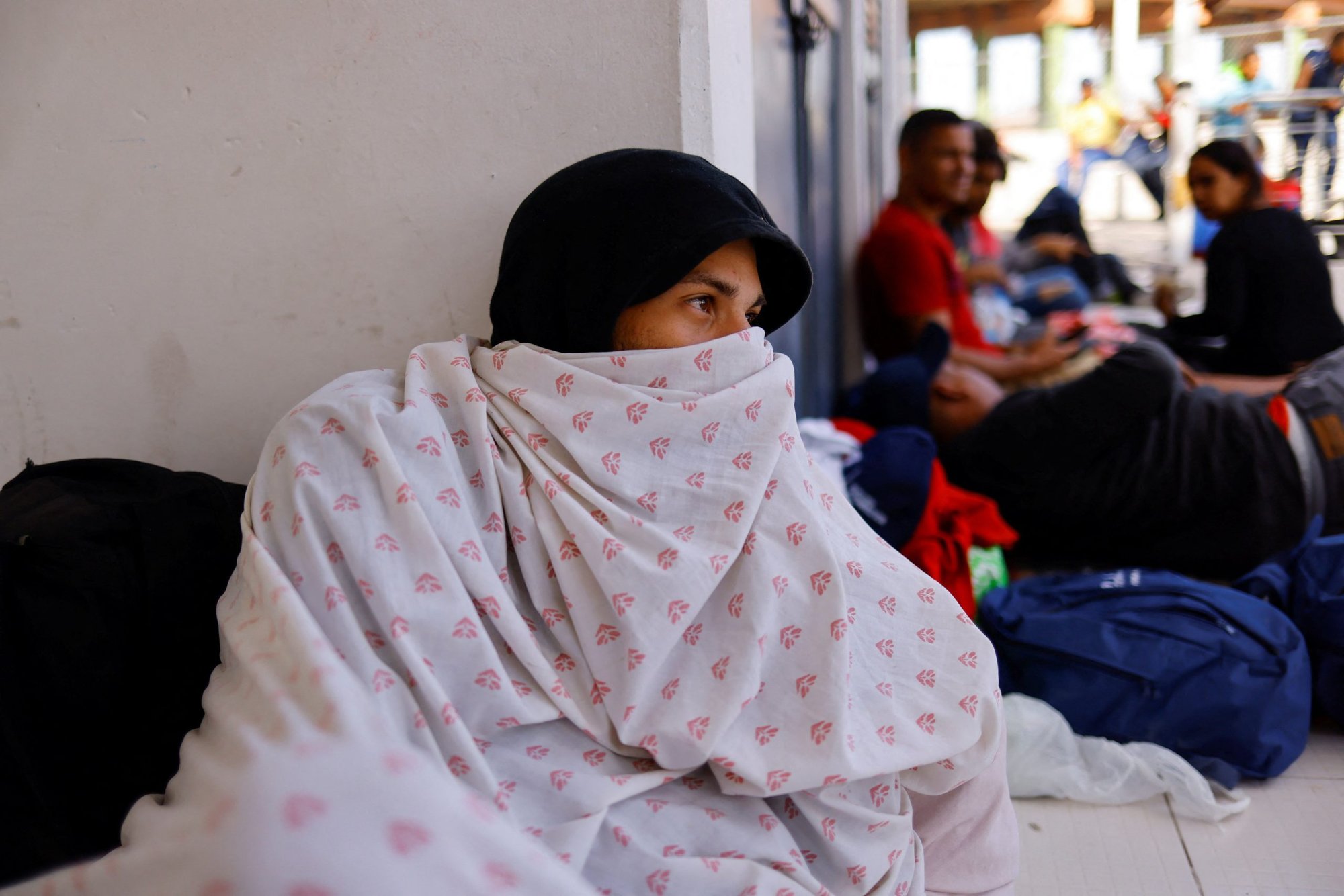 Migrantes venezolanos, expulsados de EE. UU., descansan en la frontera entre EE. UU. y México en Ciudad Juárez, México, el 16 de octubre de 2022. Fueron expulsados a México bajo el Título 42 como parte de una nueva política para frenar el número de cruces ilegales. (Foto CNS/José Luis González, Reuters)