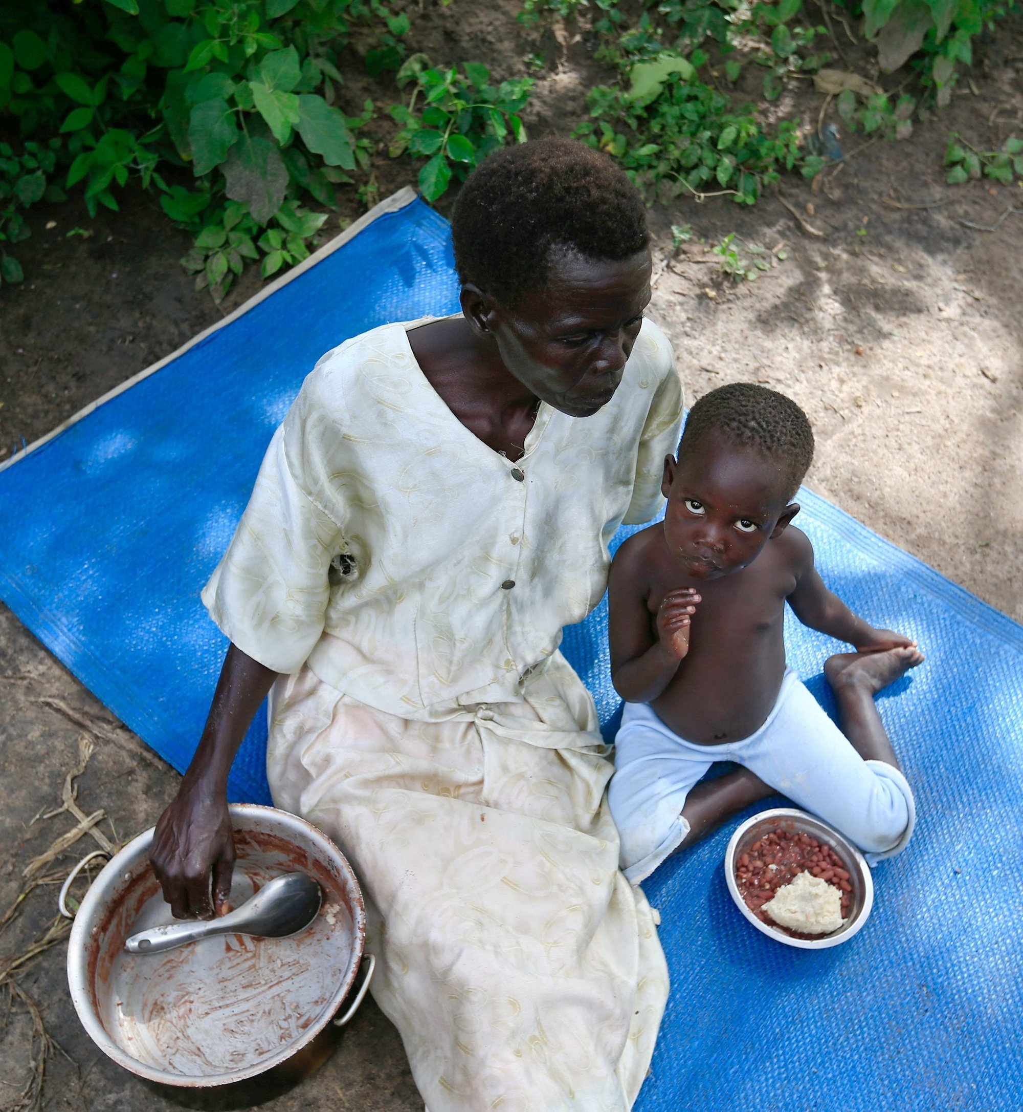Una familia de refugiados de Sudán del Sur aparece en una foto de archivo comiendo en un campo de asentamiento en Moyo, en el norte de Uganda. El obispo Alex Lodiong Sakor Eyobo, de Yei (Sudán del Sur), hace un llamamiento para obtener alimentos, ya que su región, situada en el sur del país, se ha visto afectada por las atrocidades de los rebeldes. (Foto CNS /James Akena, Reuters)
