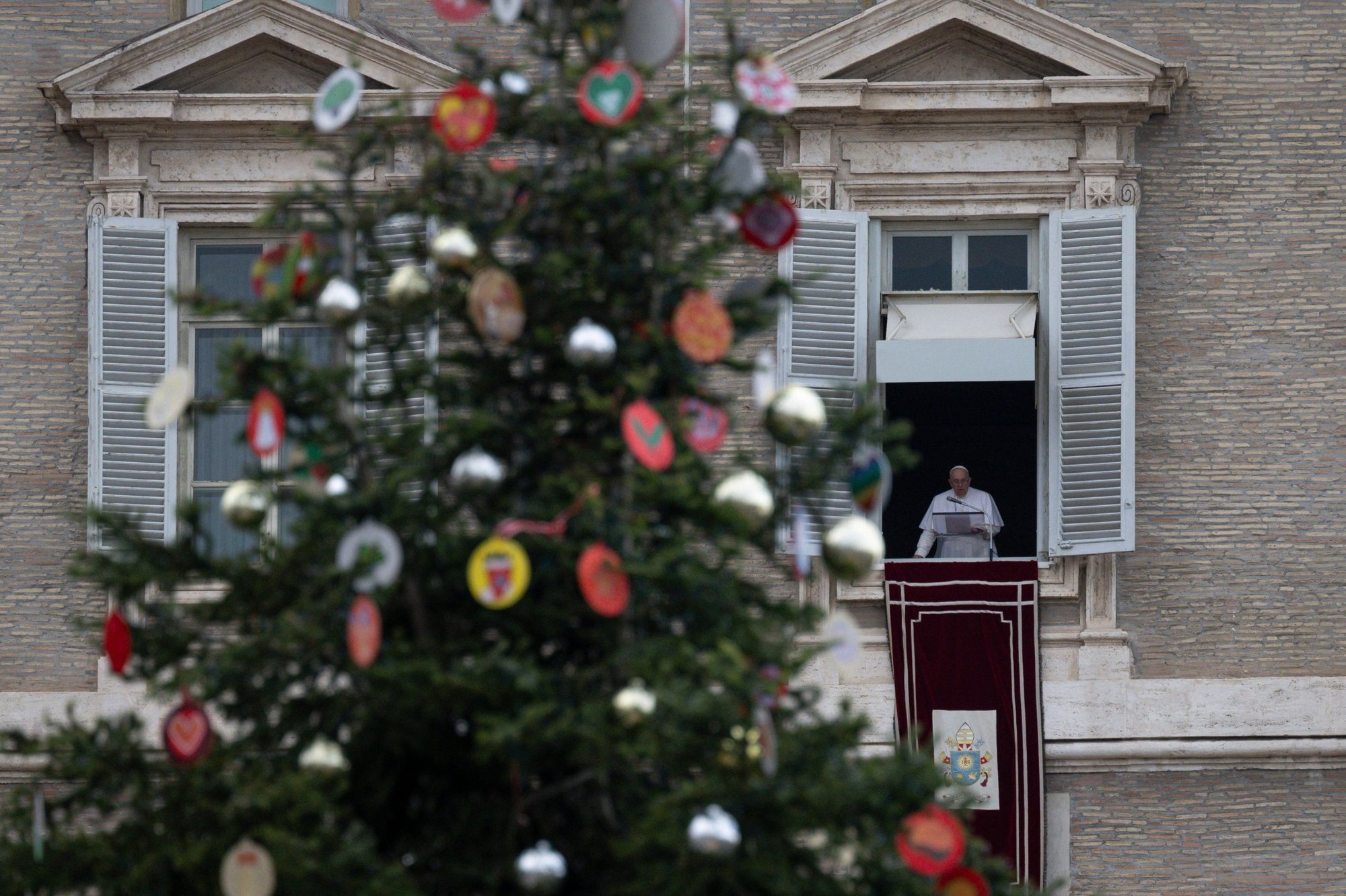El árbol de Navidad en la Plaza de San Pedro se ve mientras el Papa Francisco dirige el Ángelus desde la ventana de su estudio con vistas a la plaza en el Vaticano el 4 de diciembre de 2022. (CNS /Vatican Media)
