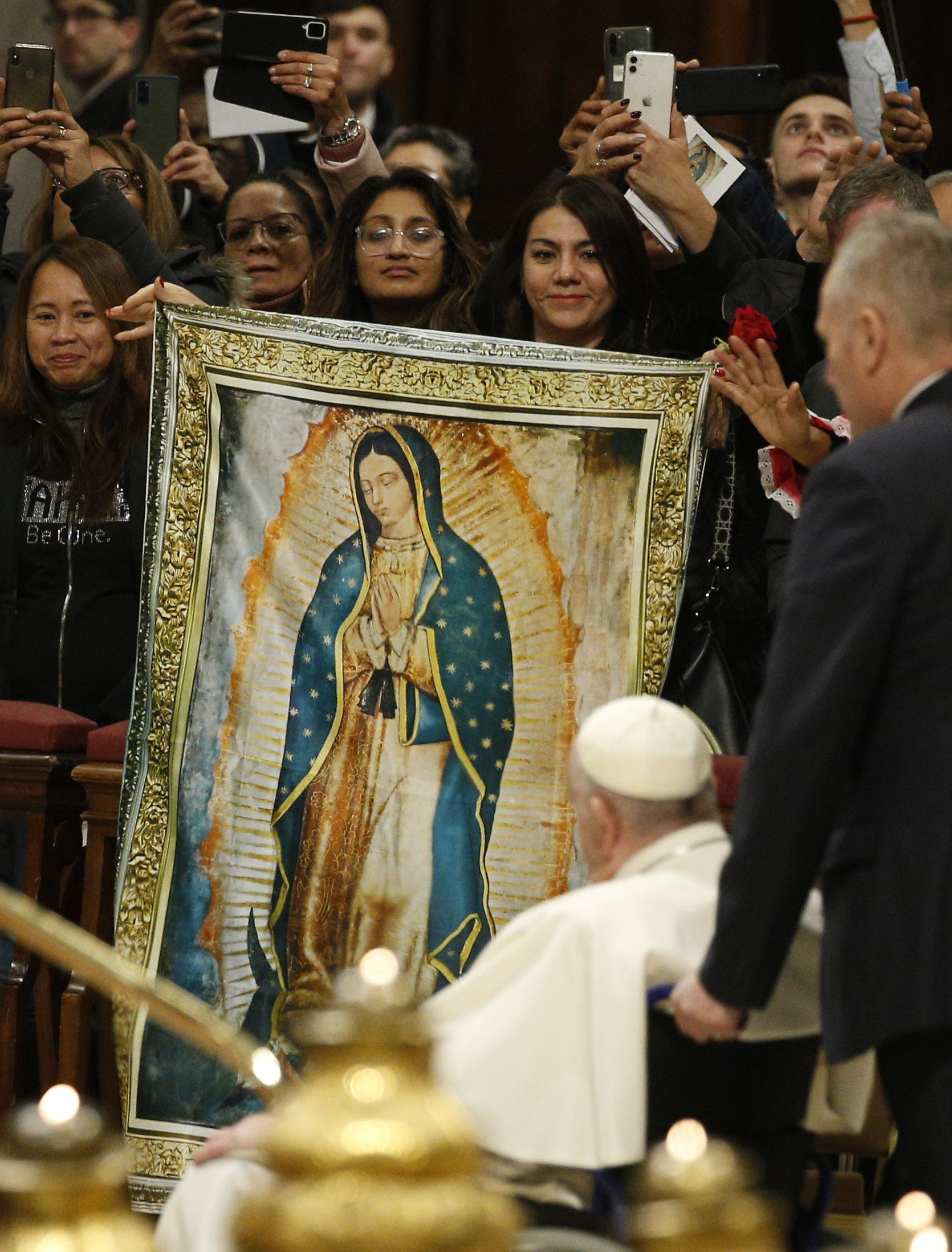 El Papa Francisco pasa un estandarte de Nuestra Señora de Guadalupe al salir después de presidir la misa que marca la fiesta de Nuestra Señora de Guadalupe en la Basílica de San Pedro en el Vaticano el 12 de diciembre de 2022. (CNS /Paul Haring)
