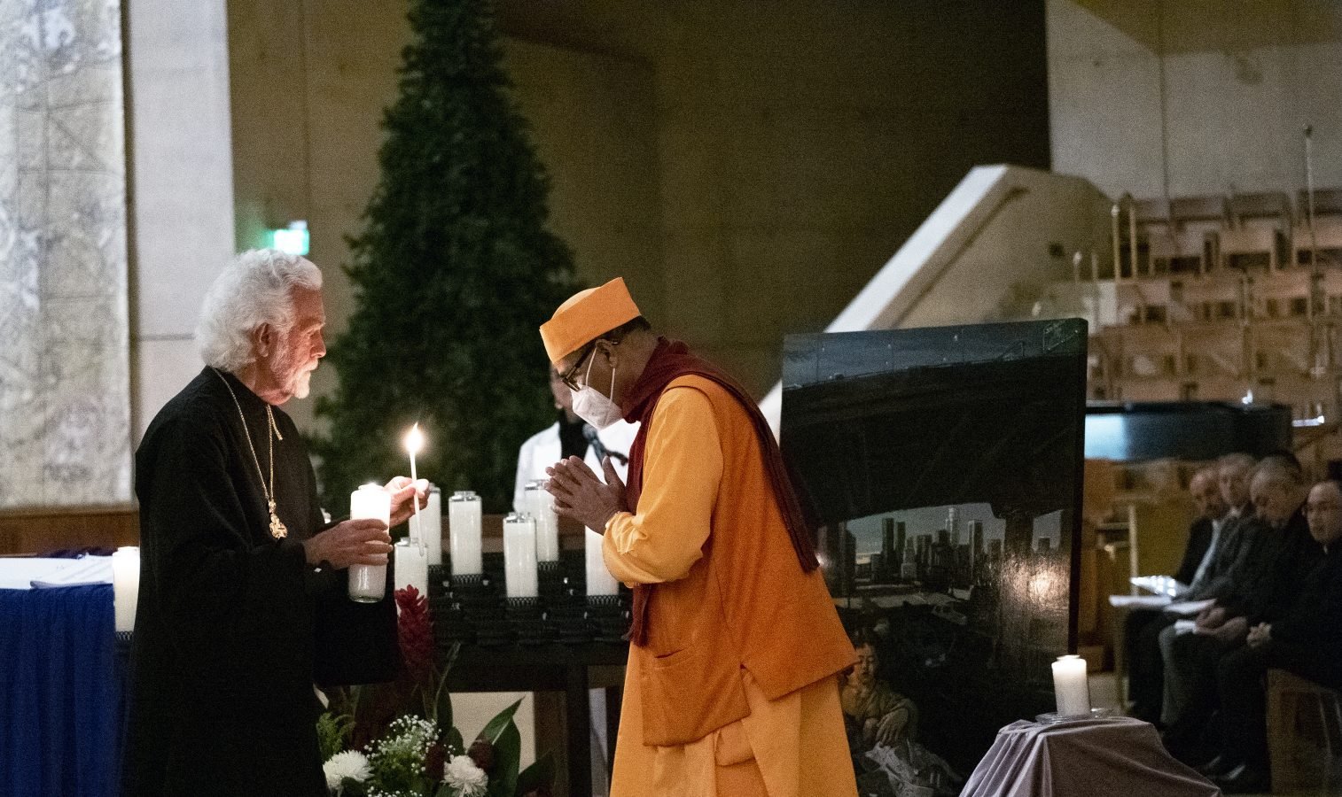 Rvdo. Alexei Smith, oficial interreligioso de la Arquidiócesis, ayuda a un invitado a encender una vela en recuerdo de las personas sin hogar que han muerto en las calles de Los Ángeles en una vigilia interreligiosa en la Catedral de Nuestra Señora de los Ángeles el 21 de diciembre de 2022. (Víctor Alemán)