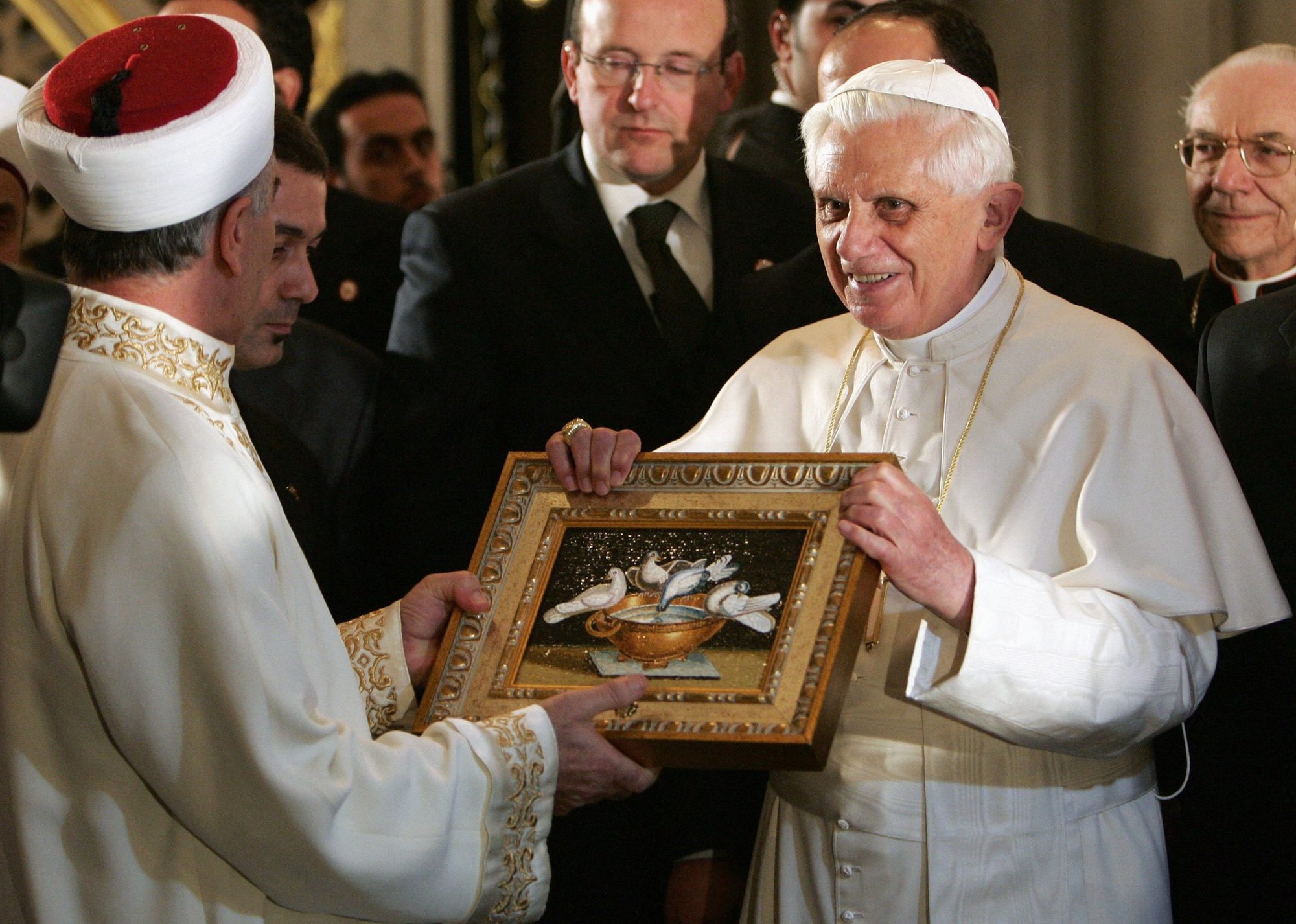 El Papa Benedicto XVI ofrece un regalo a Mustafa Cagrici, gran muftí de Estambul, durante su visita a la Mezquita Azul de Estambul, Turquía, 30 de noviembre de 2006. La inesperada oración del Papa en la mezquita calmó la ira en el mundo musulmán por una cita sobre el Islam en su conferencia del 12 de septiembre de 2006 en Ratisbona, Alemania. (CNS /Patrick Hertzog, pool via Reuters)