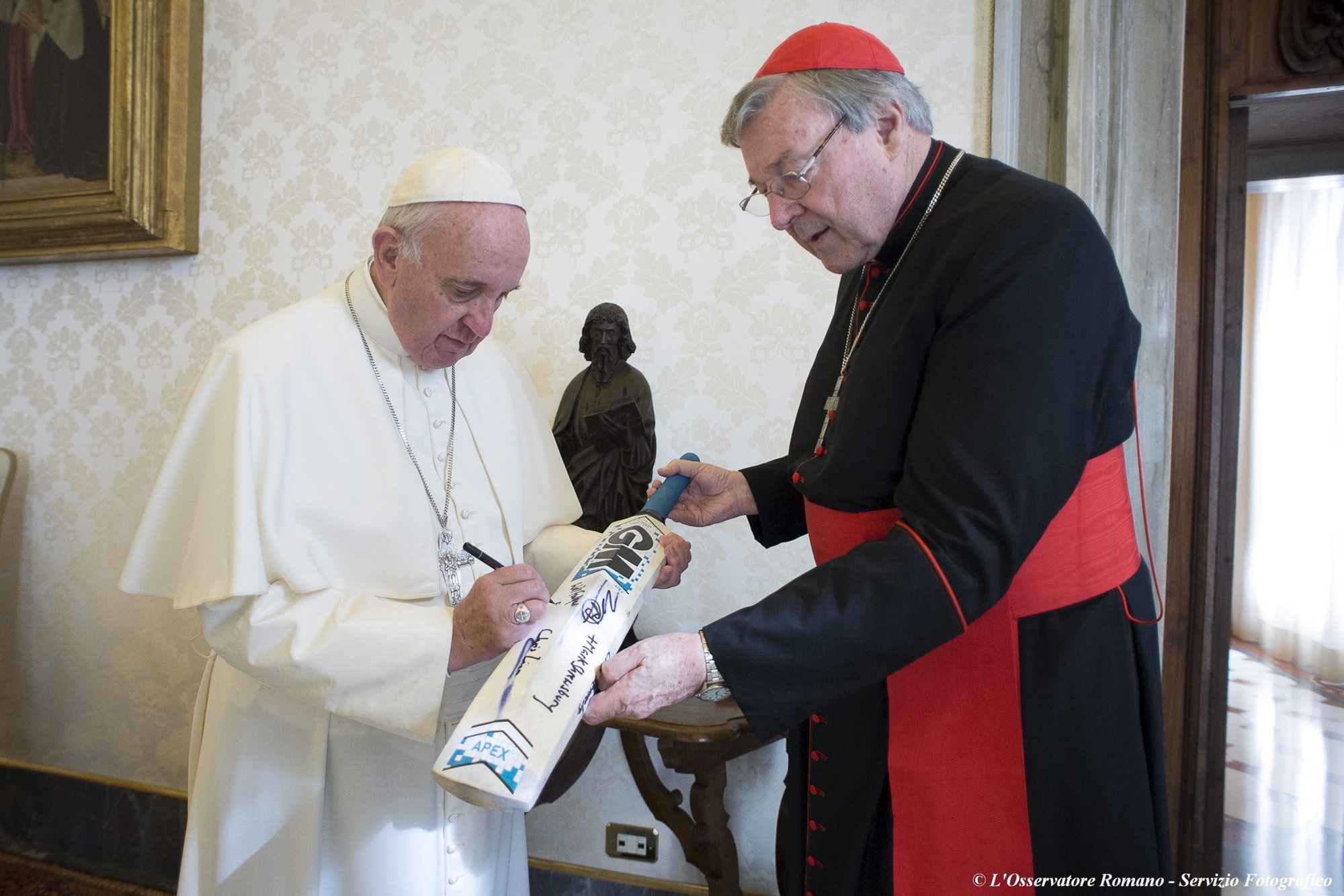 El Papa Francisco firma un bate de cricket de un equipo de cricket de Canterbury recibido del cardenal australiano George Pell en el Vaticano en esta foto de archivo del 29 de octubre de 2015. El cardenal Pell, ex prefecto de la Secretaría para la Economía del Vaticano, falleció el 10 de enero en Roma a la edad de 81 años. (CNS/L'Osservatore Romano via Reuters)