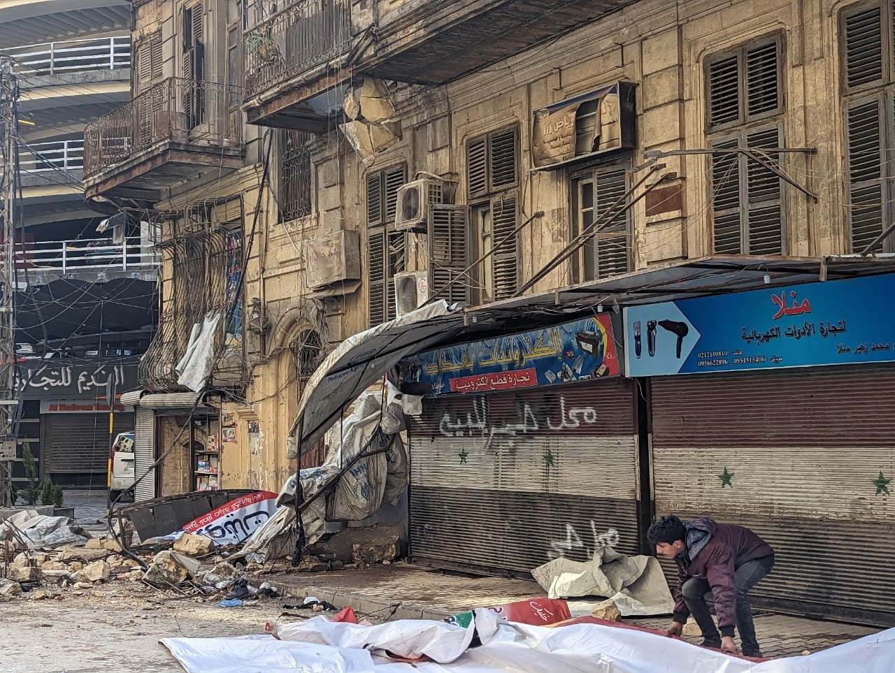 Un hombre limpia el exterior de un edificio parcialmente destruido en Alepo, Siria, el 7 de febrero de 2023, un día después de que dos fuertes terremotos destruyeran edificios y mataran a miles de personas en la región fronteriza entre Turquía y Siria. (CNS photo/Cortesía de Ayuda a la Iglesia Necesitada, Xavier Stephen Bisits)