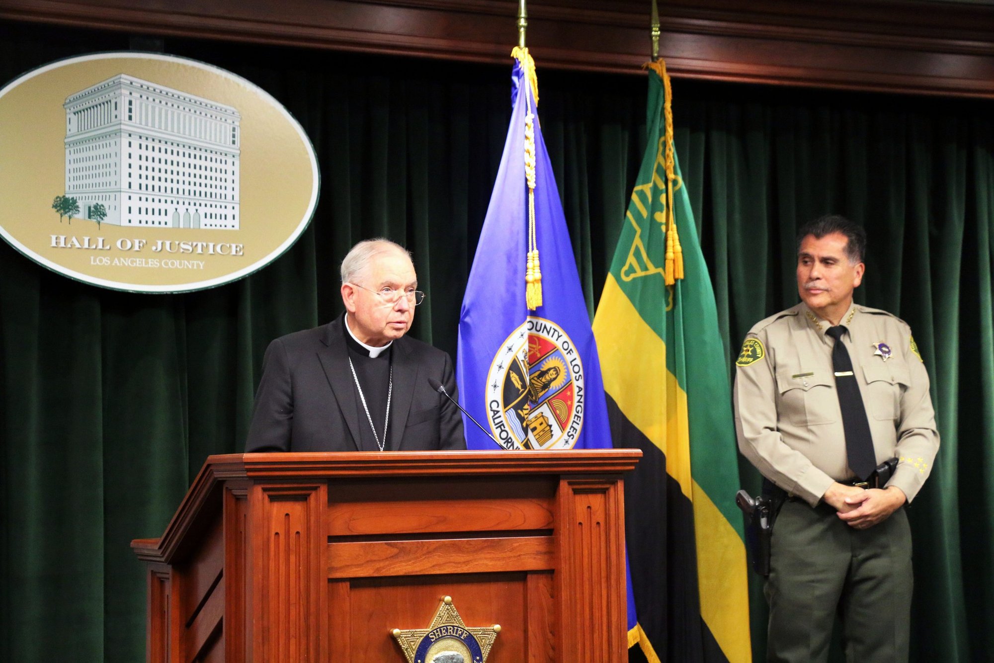 El arzobispo de Los Ángeles, José H. Gómez, habla ante la mirada del sheriff del condado de Los Ángeles, Robert Luna, durante una rueda de prensa celebrada el 20 de febrero de 2023 tras la detención de Carlos Medina, de 65 años, sospechoso del asesinato del obispo auxiliar David G. O'Connell. El obispo O'Connell fue encontrado muerto de una sola herida de bala el 18 de febrero en su casa de Hacienda Heights, un barrio al este de Los Ángeles. (Foto OSV News/Pablo Kay)