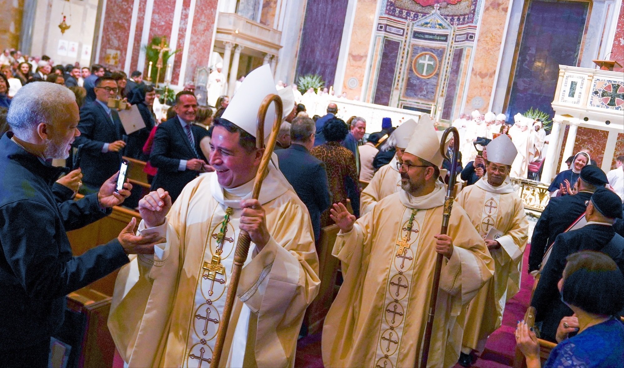 Después de sus ordenaciones como nuevos obispos auxiliares de Washington 21 de febrero 2023, en la Catedral de San Mateo, el Obispo Evelio Menjívar-Ayala, y el Obispo Juan Esposito-García, en el centro, bendicen a la congregación. A la derecha, el Obispo Auxiliar de Washington Roy Campbell Jr. (Foto OSV News /Mihoko Owada, Catholic Standard)