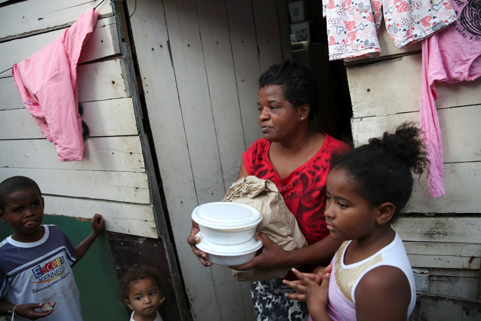 Habitantes de un barrio pobre de Río de Janeiro reciben comida y pan de los miembros del Instituto doAcao el 24 de junio de 2021. El creciente número de personas que se enfrentan a la inseguridad alimentaria en Brasil llevó a los obispos del país a centrarse en "Fraternidad y Hambre" durante su Campaña de Fraternidad 2023 esta Cuaresma. (OSV News /Ricardo Moraes, Reuters)