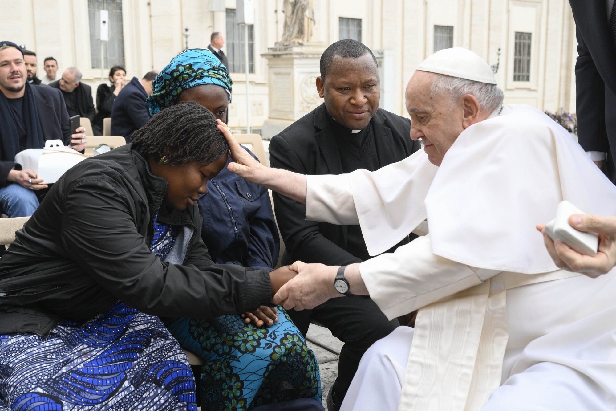 El Papa Francisco bendice a Maria Joseph, superviviente de la persecución cristiana en Nigeria, tras su audiencia general del 8 de marzo de 2023. La acompañan a su izquierda Janada Marcus, otra superviviente, y el padre Joseph Bature Fidelis, director de un centro de traumatología para víctimas del terrorismo en Nigeria. (CNS /Vatican Media)