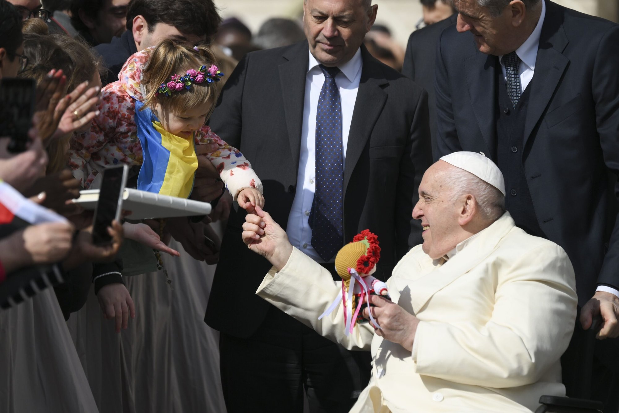 El Papa Francisco agradece a una niña ucraniana el regalo de una muñeca tras su audiencia general en la Plaza de San Pedro el 5 de abril de 2023. Durante la audiencia, en la que rezó por la paz en Ucrania, el Papa pidió a la gente que recordara a las madres ucranianas y rusas que han perdido a sus hijos en la guerra. (foto de CNS/Vatican Media)