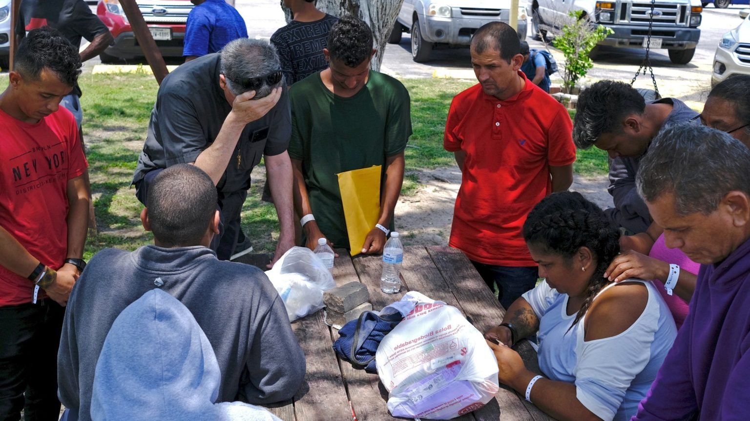 El padre oblato Kevin Collins, párroco de la parroquia de San Eugenio de Mazenod, se lleva la mano a la frente en oración con los migrantes en el Centro Obispo Enrique San Pedro Ozanam, un refugio para migrantes y personas sin hogar, tras un incidente mortal en el que un coche arrolló a los peatones en una parada de autobús cercana en Brownsville, Texas, 7 de mayo de 2023. (Foto OSV News/Miguel Roberts, Reuters)