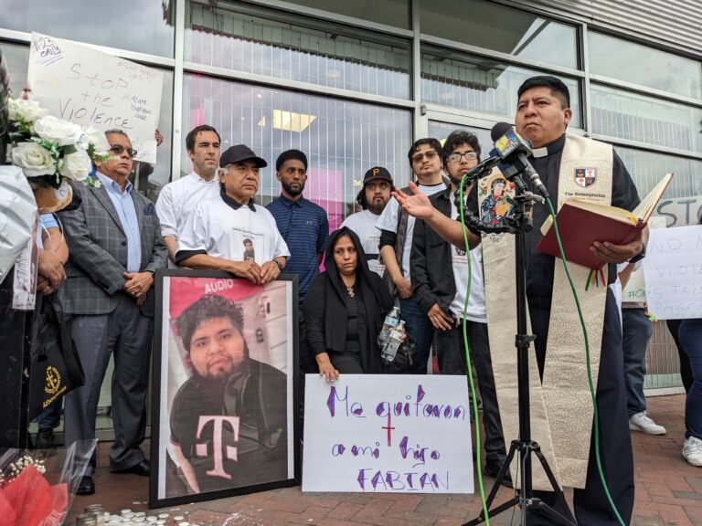El Padre Redentorista Alipio Flores, vicario parroquial del Sagrado Corazón de Jesús en la zona de Highlandtown en Baltimore, reza por la paz y la justicia durante una vigilia en T-Mobile en Canton, donde Fabián Sánchez-González fue baleado mortalmente el 30 de abril. De izquierda a derecha están el concejal de la ciudad, Zeke Cohen; el padre de Fabián, Humberto Sánchez; el alcalde de Baltimore, Brandon M. Scott; la madre de Fabián, Alma Rosa González; y los hermanos de Fabián; Jesús Sánchez-González, Julio Contreras y Carlos Sánchez-González. (Foto OSV News/Priscila González de Doran, especial para el Catholic Review)