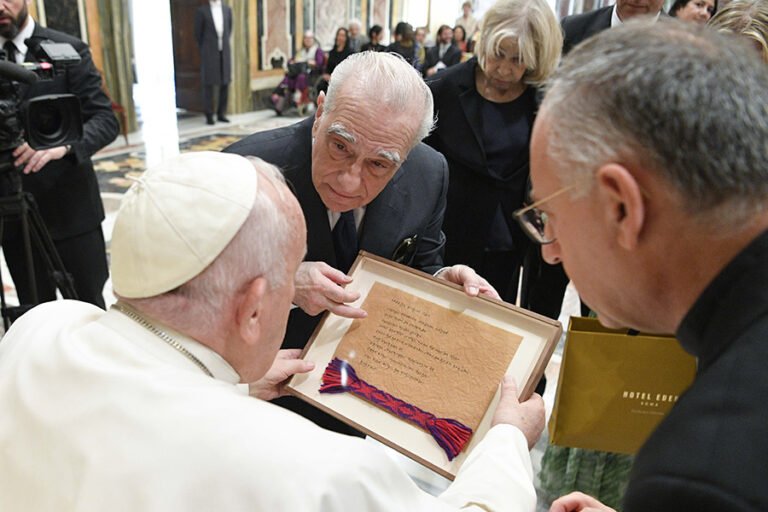 El director Martin Scorsese entrega al Papa Francisco una copia enmarcada del Padre Nuestro escrito en la lengua de la Nación Osage al final de una audiencia en el Vaticano el 27 de mayo de 2023. Scorsese trabajó con los Osage, un pueblo nativo americano, en Oklahoma en el rodaje de su última película, "Asesinos de la luna florida". (CNS photo/Vatican Media)