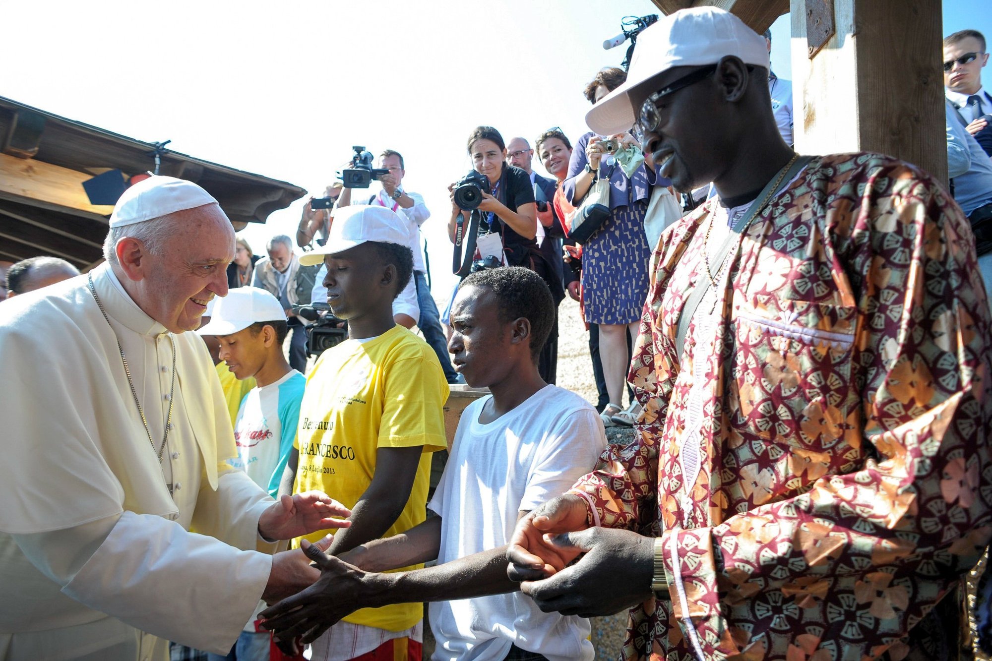 El Papa Francisco saluda a inmigrantes en el puerto de Lampedusa, Italia, en esta foto de archivo del 8 de julio de 2013. Durante su visita, el pontífice instó a la gente a no formar parte de la "globalización de la indiferencia" ante la difícil situación de los millones de personas en todo el mundo que son migrantes y refugiados. (Foto CNS/L'Osservatore Romano vía CPP)