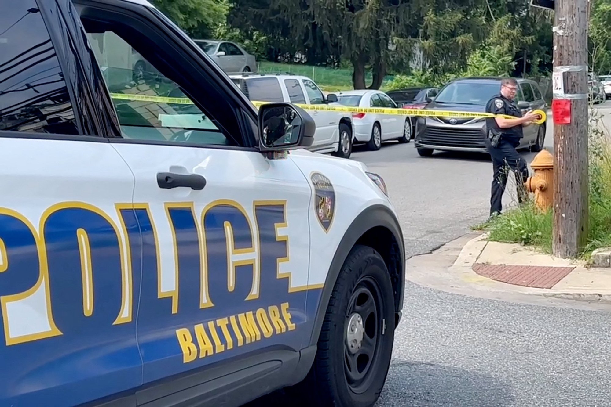 Un agente de policía, en una imagen de vídeo, sujeta la cinta de la escena del crimen a un poste el 2 de julio de 2023, tras un tiroteo masivo en el lugar de una fiesta del fin de semana del 4 de julio en Baltimore. El arzobispo de Baltimore, William E. Lori, pidió oraciones por las víctimas tras el tiroteo masivo que dejó dos muertos y más de dos docenas de heridos, la mayoría adolescentes. (Foto OSV News/Reuters)