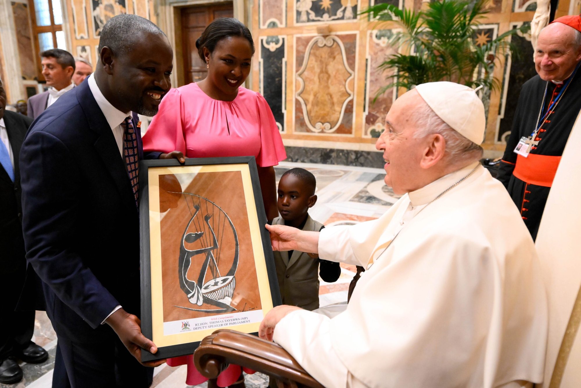 Thomas Tayebwa, vicepresidente del parlamento ugandés, con su mujer y su hijo, entrega un regalo al Papa Francisco durante un encuentro con miembros de la Red Internacional de Legisladores Católicos en el Vaticano el 26 de agosto de 2023. (Foto de CNS/Vatican Media)